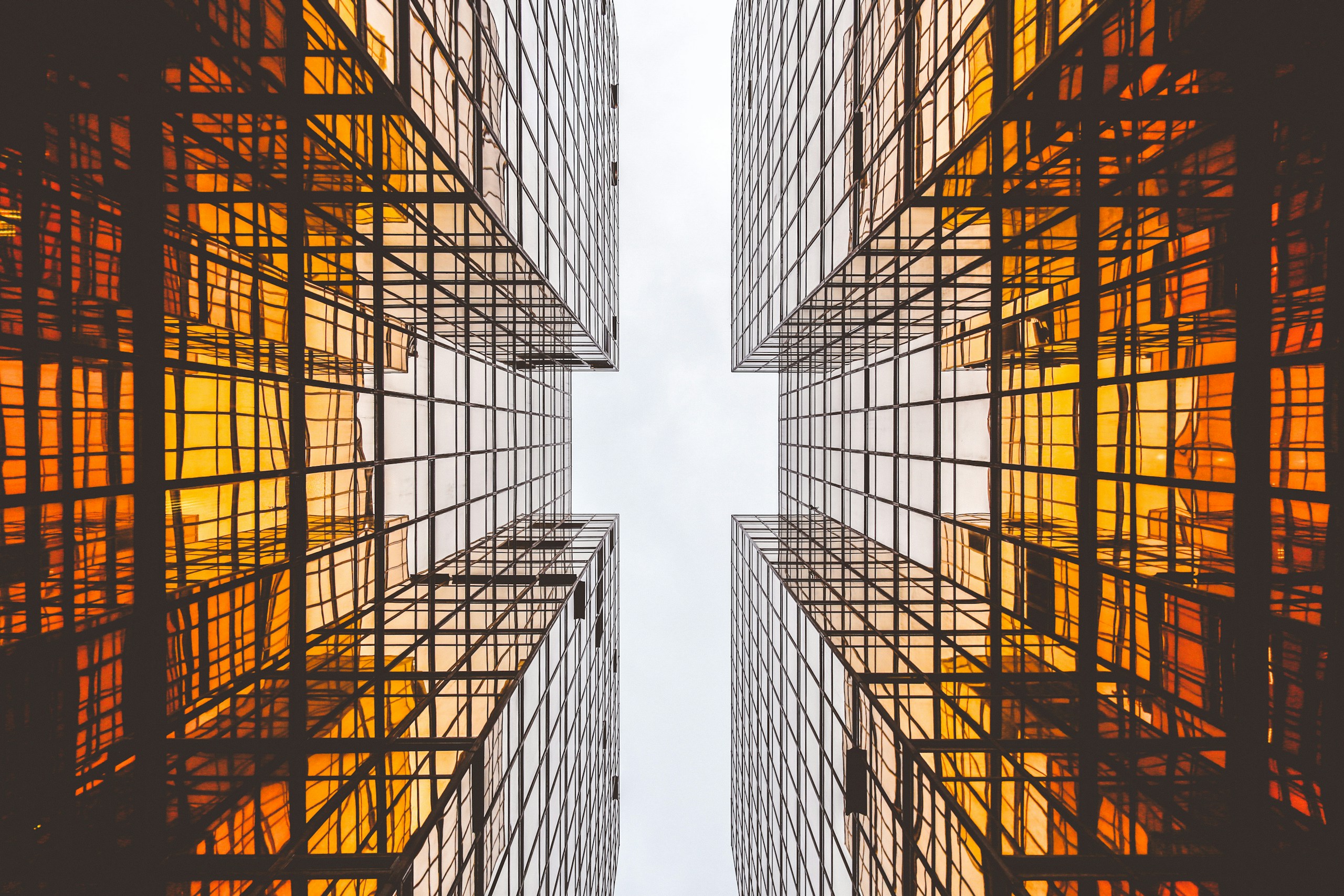 Worm's-eye view of orange reflective glass skyscrapers HD Wallpaper