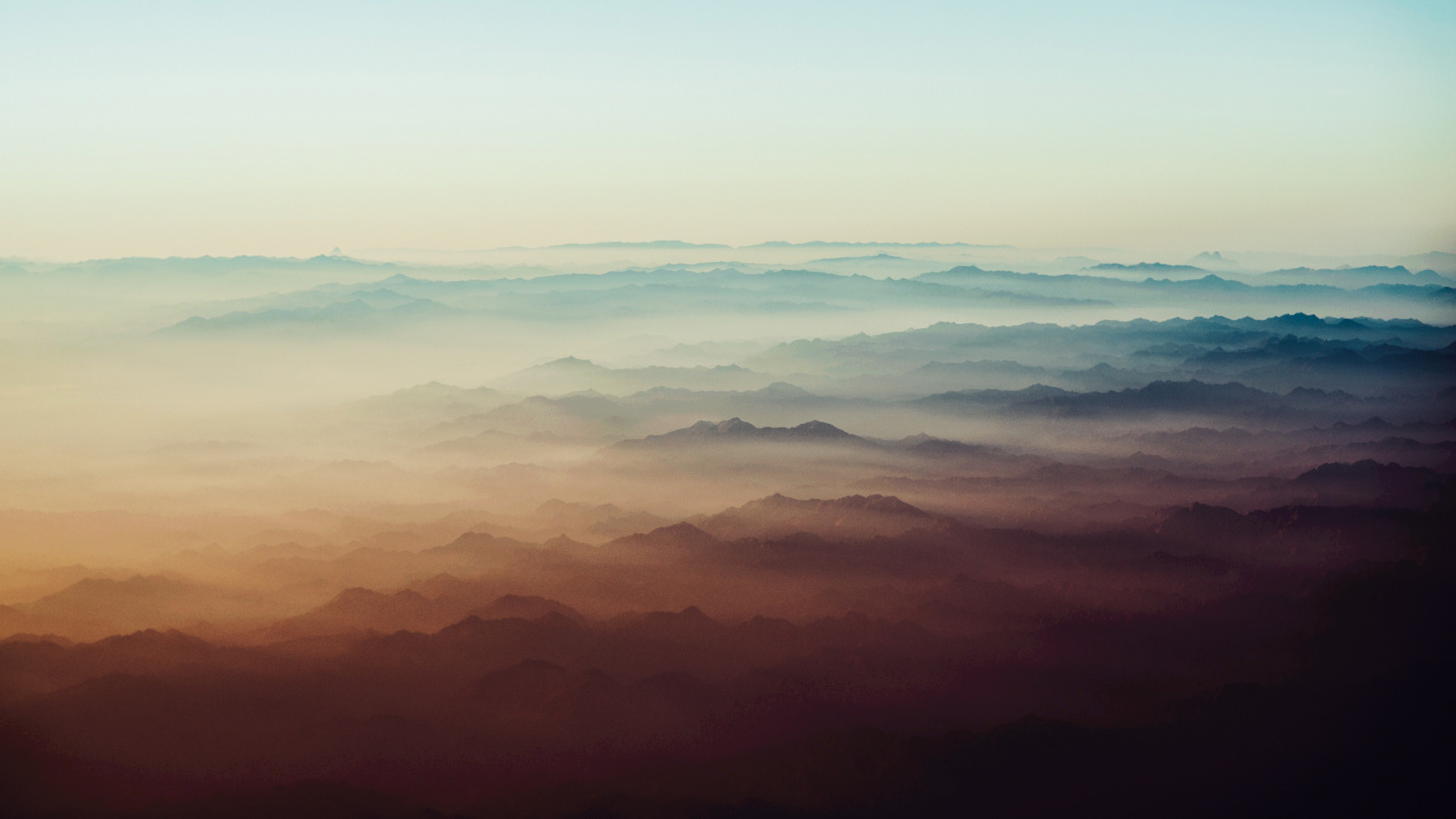 Layered Mountain Ranges Shrouded in Mist HD Wallpaper