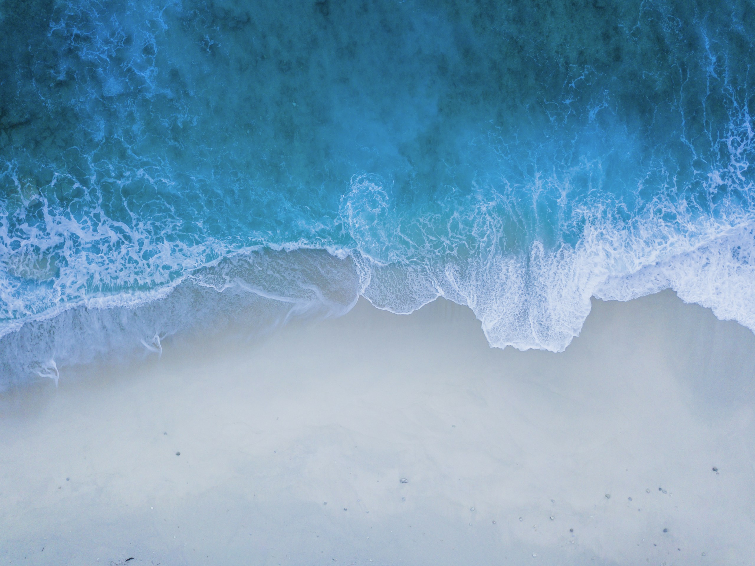 Aerial View of Ocean Waves Crashing on Sandy Beach HD Wallpaper