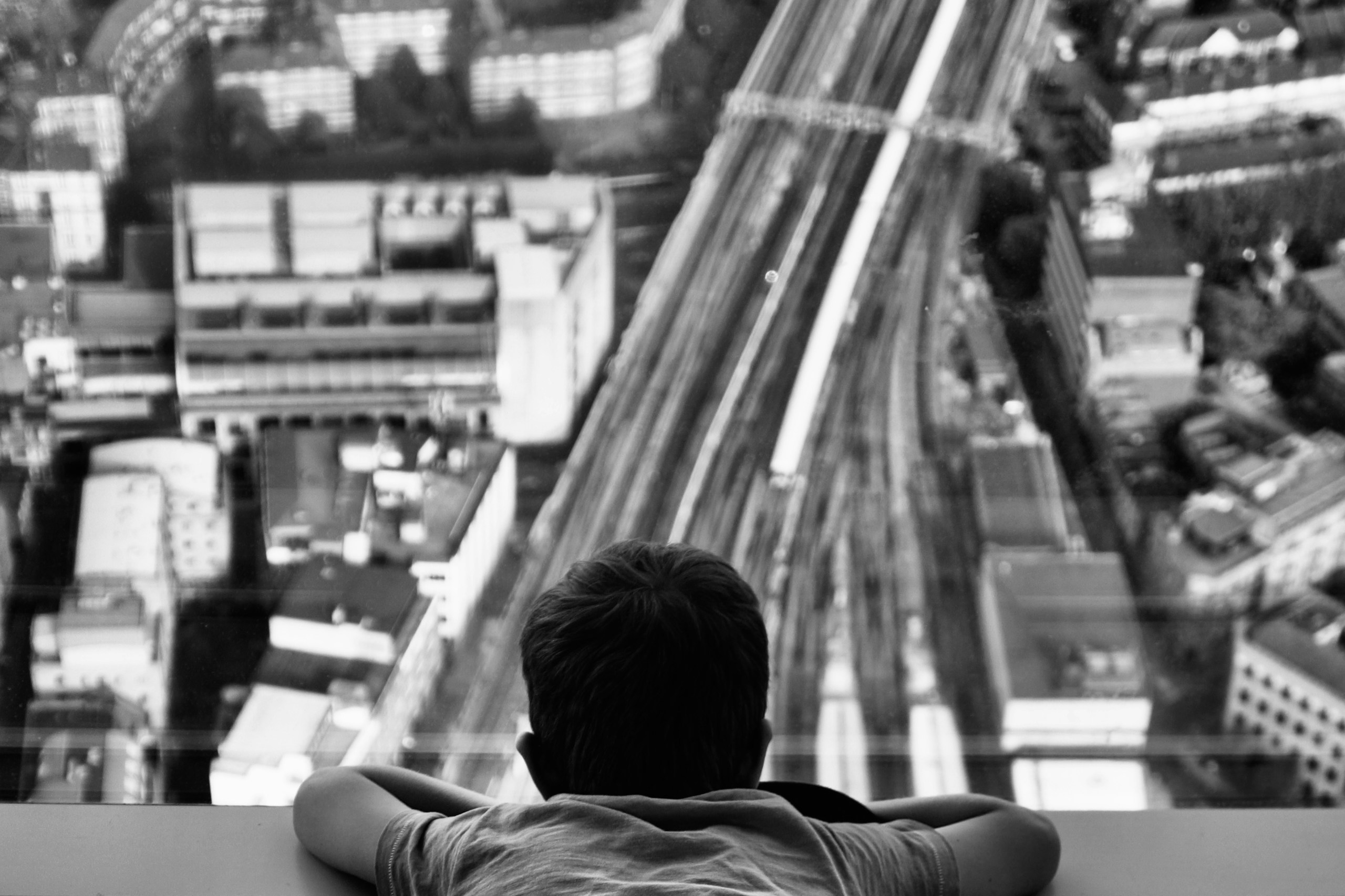 Child looking down at a city HD Wallpaper