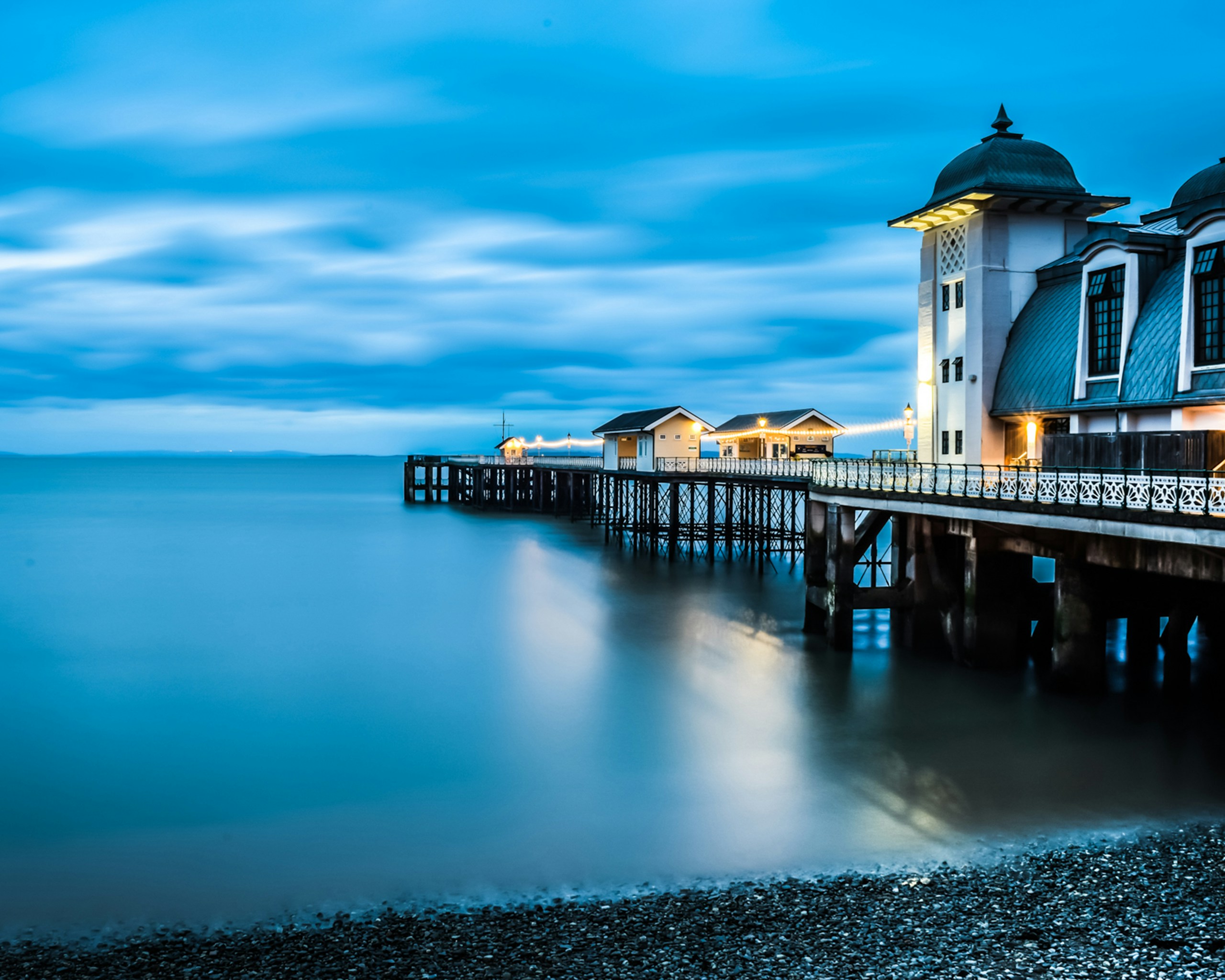 Illuminated Pier and Pavilion over Calm Blue Water HD Wallpaper