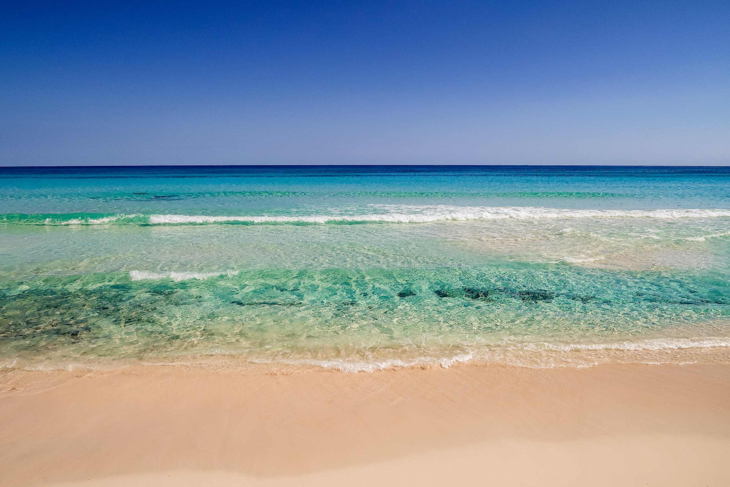 Clear turquoise ocean waves on a sandy beach HD Wallpaper