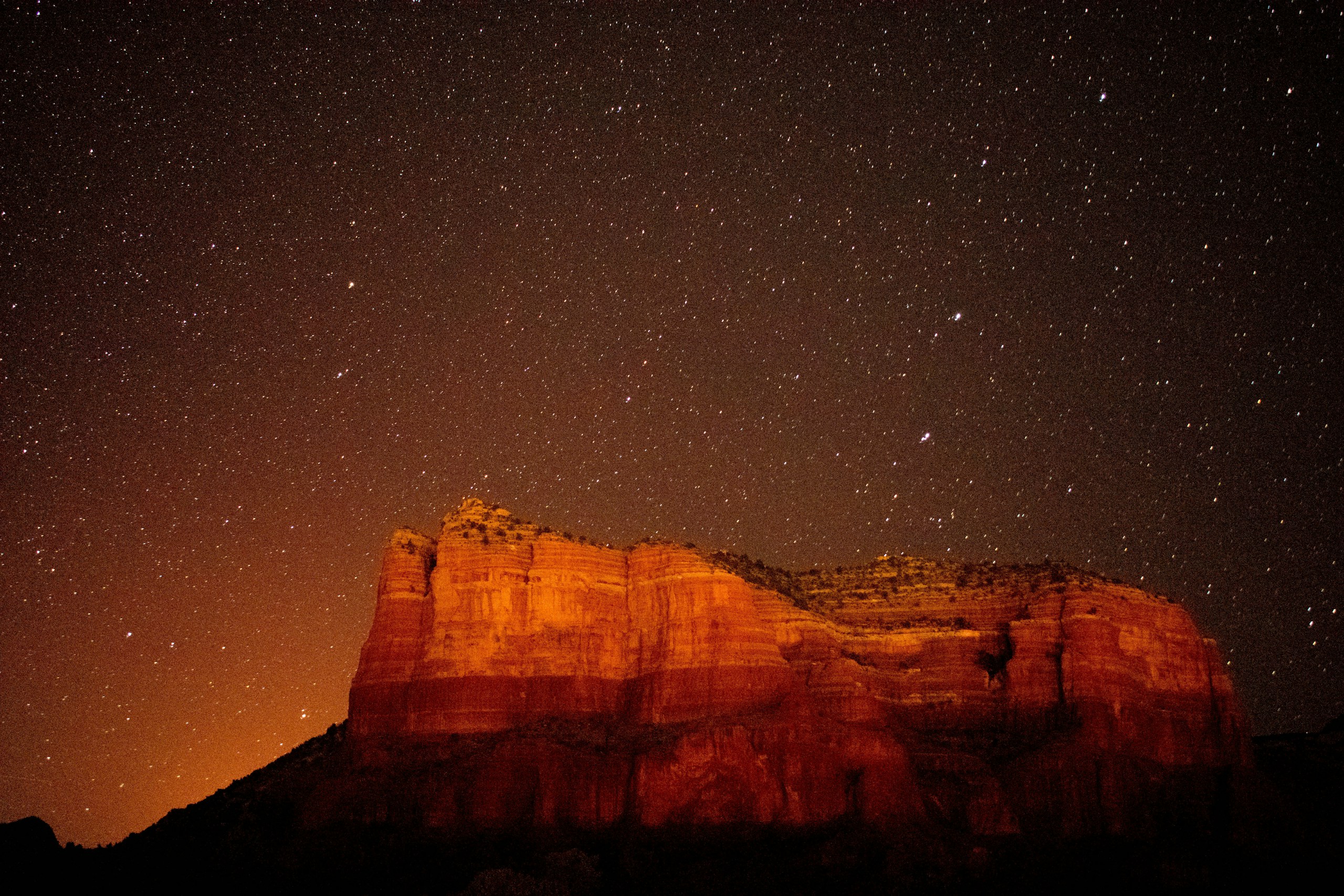Red rock formation under a starry night sky HD Wallpaper
