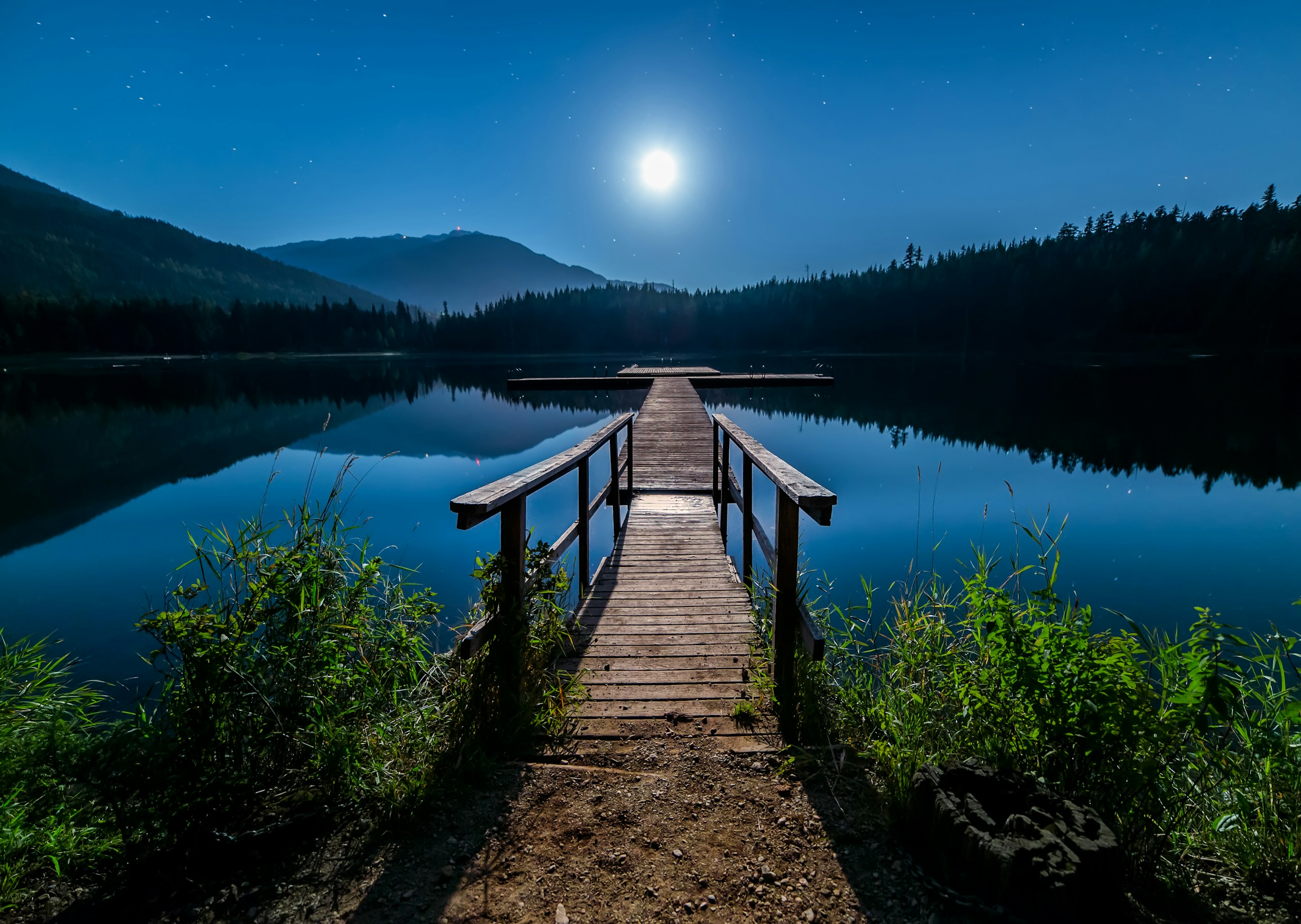 Wooden dock on a calm lake under a full moon HD Wallpaper