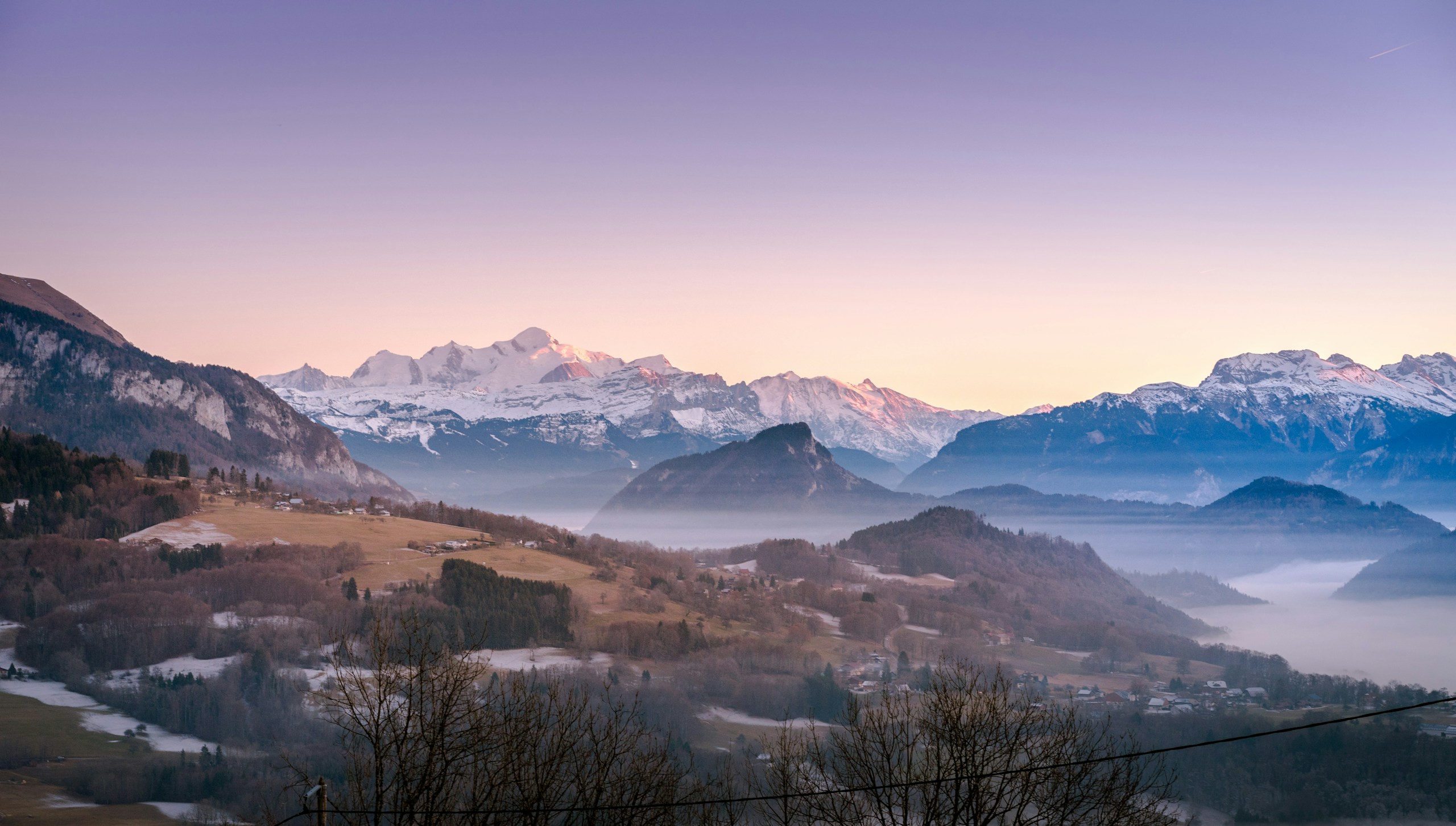Snowy mountain range at sunrise with valley fog HD Wallpaper