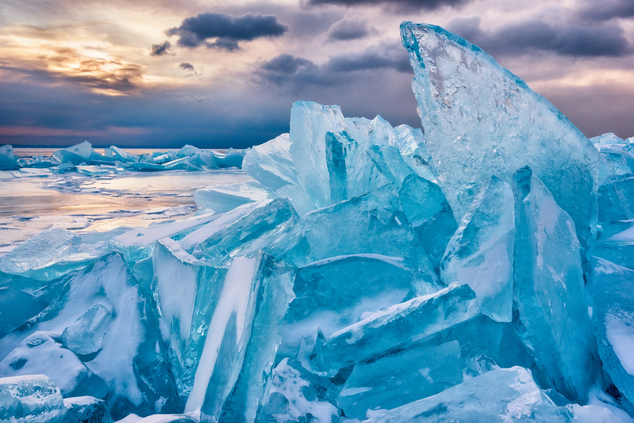 Turquoise ice hummocks on a frozen lake at sunset HD Wallpaper