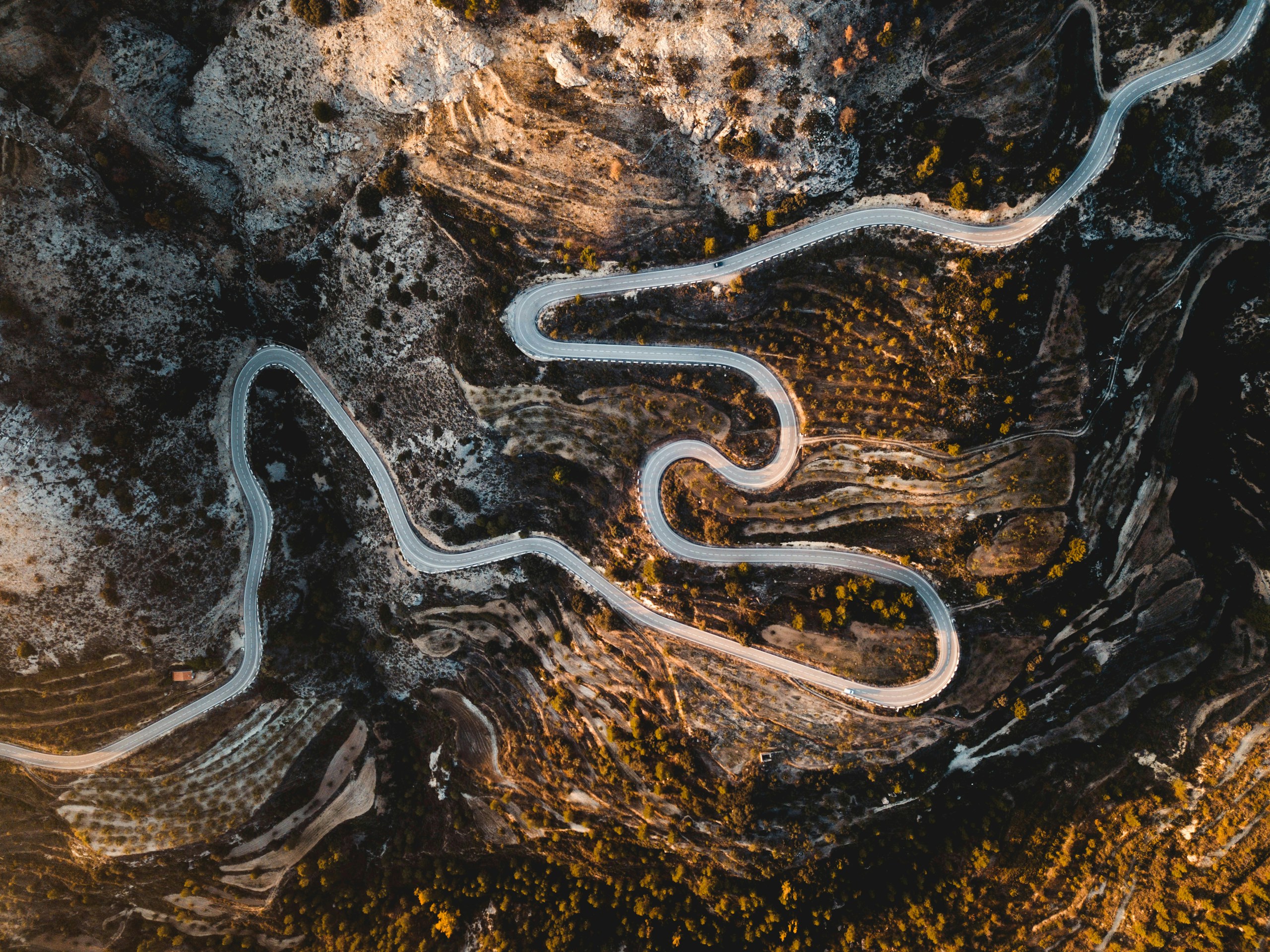 Aerial view of a winding mountain road HD Wallpaper
