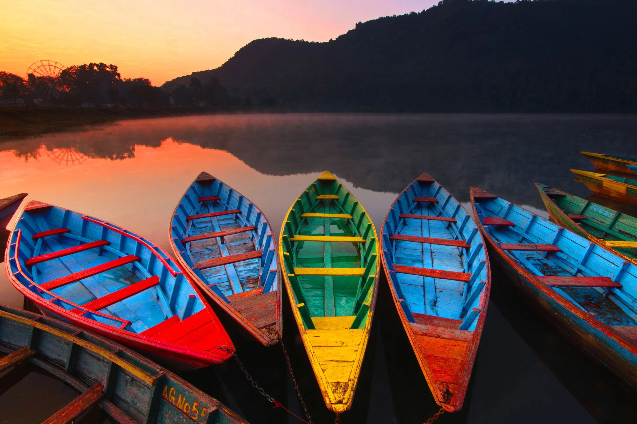 Colorful wooden boats on a calm lake at sunrise HD Wallpaper