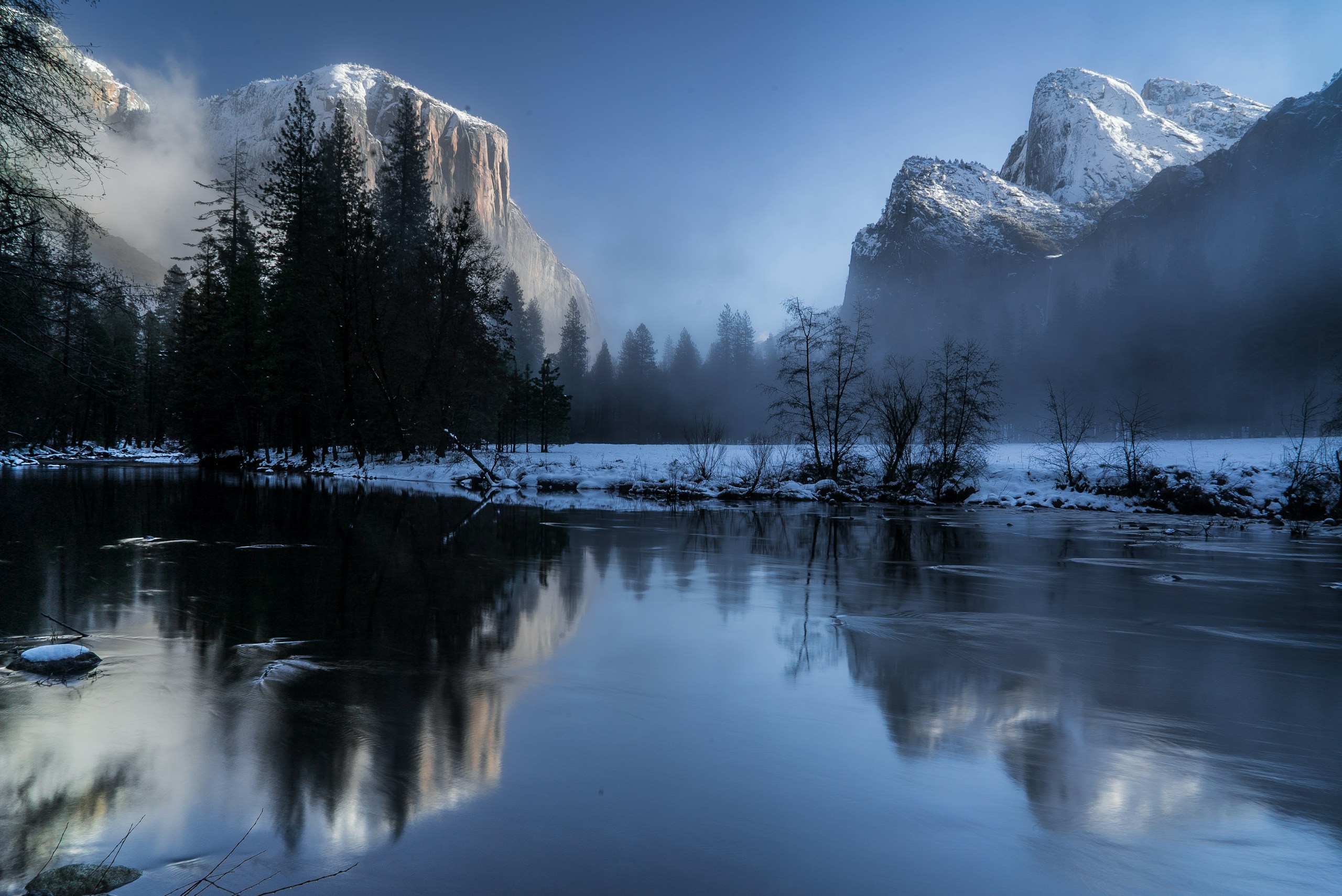 Snowy mountains reflected in a calm river during winter HD Wallpaper