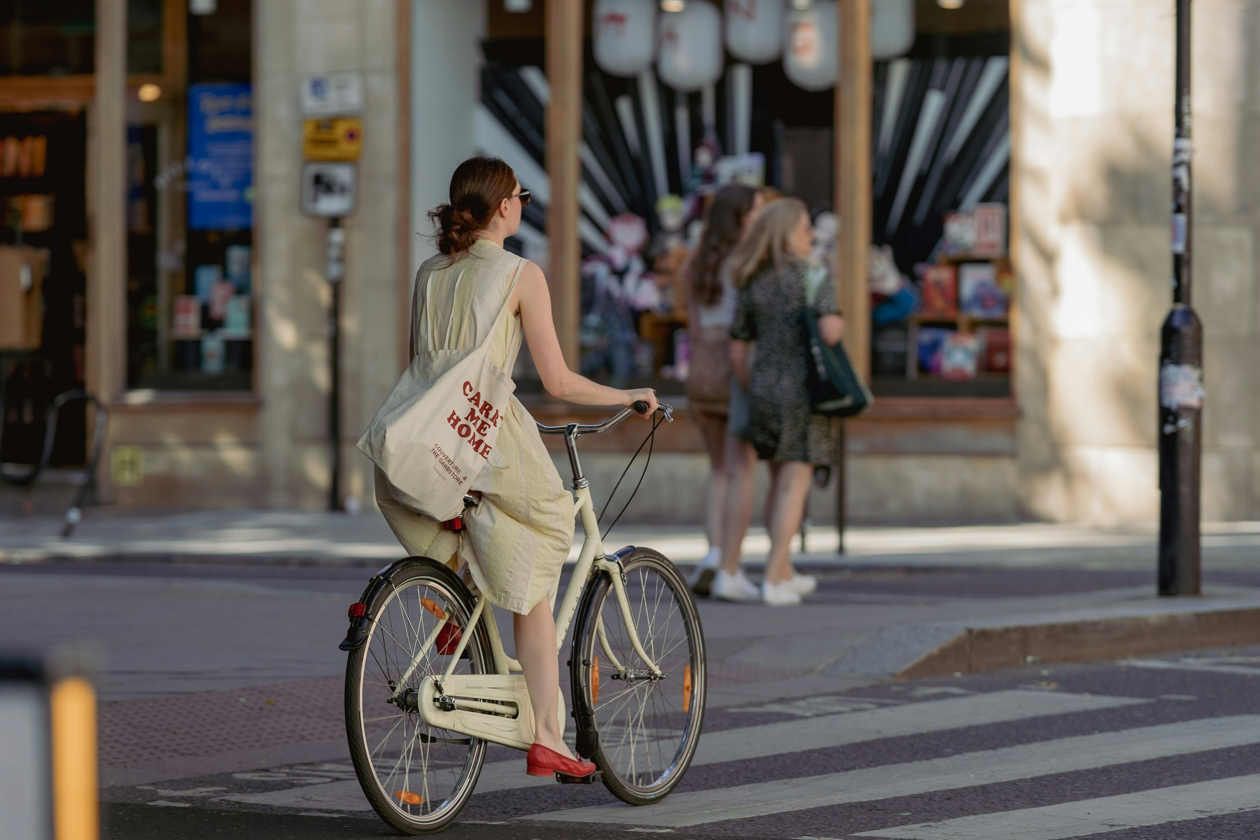 Woman in Yellow Dress Riding a Bicycle on City Street HD Wallpaper
