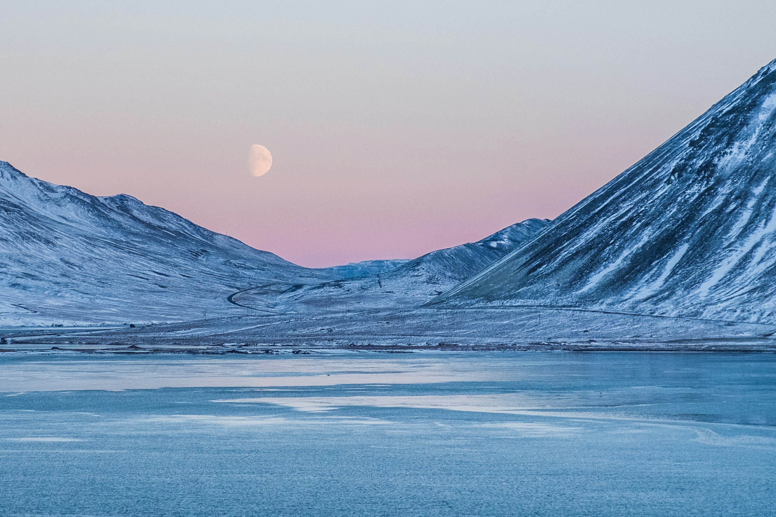 Snowy mountains and frozen lake under a twilight moon HD Wallpaper