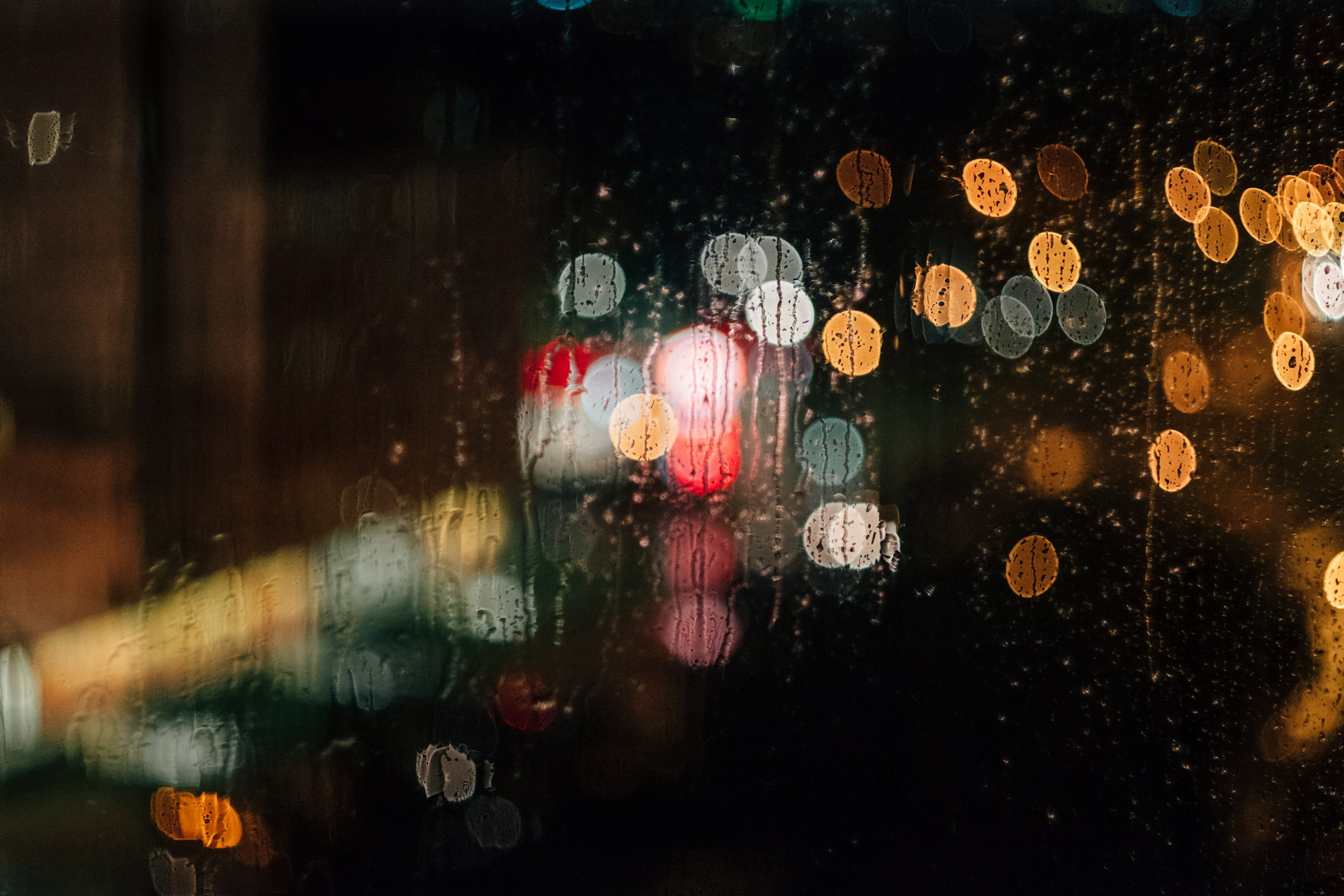 Raindrops on window with colorful bokeh city lights HD Wallpaper