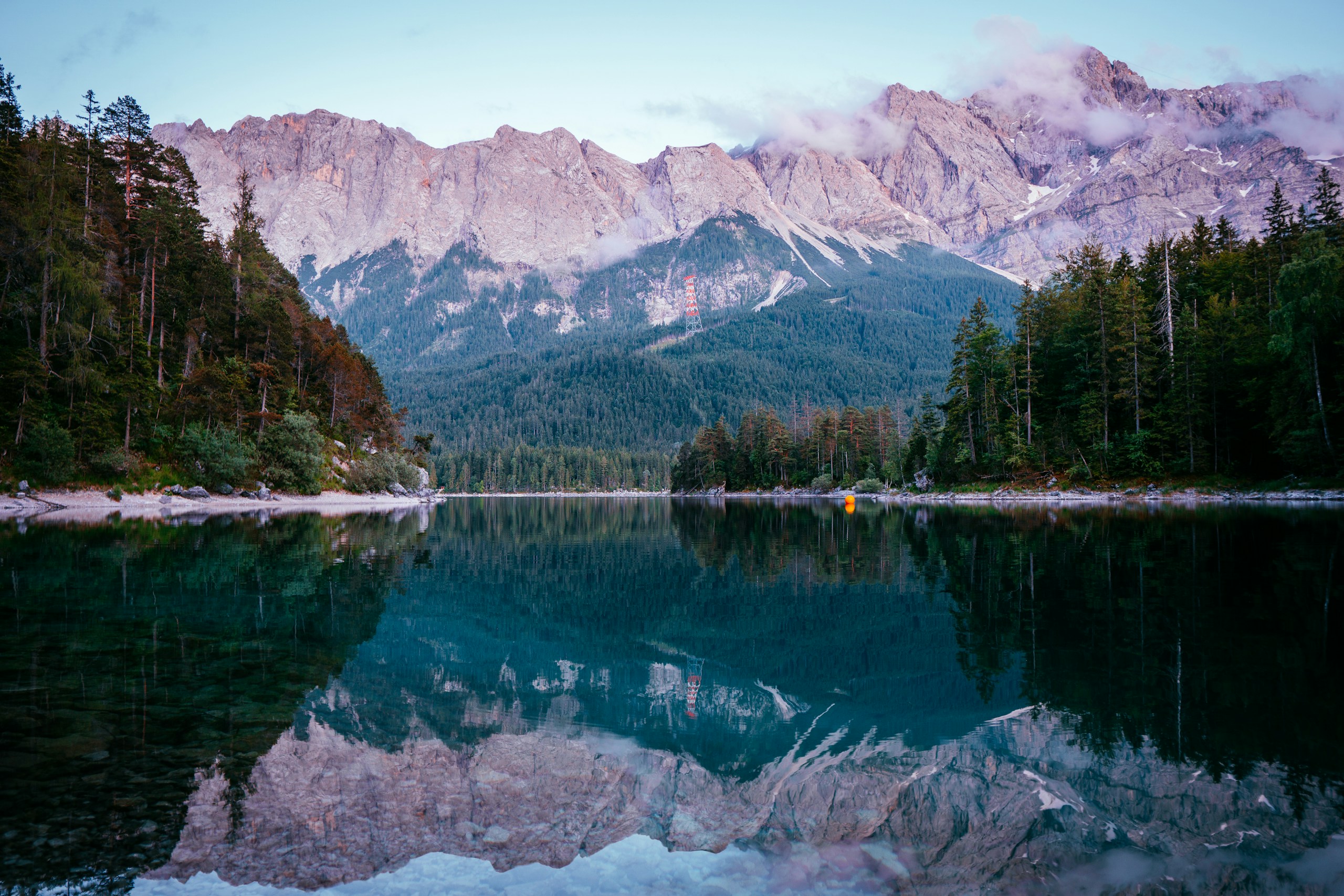 Mountain range reflected in a calm alpine lake HD Wallpaper