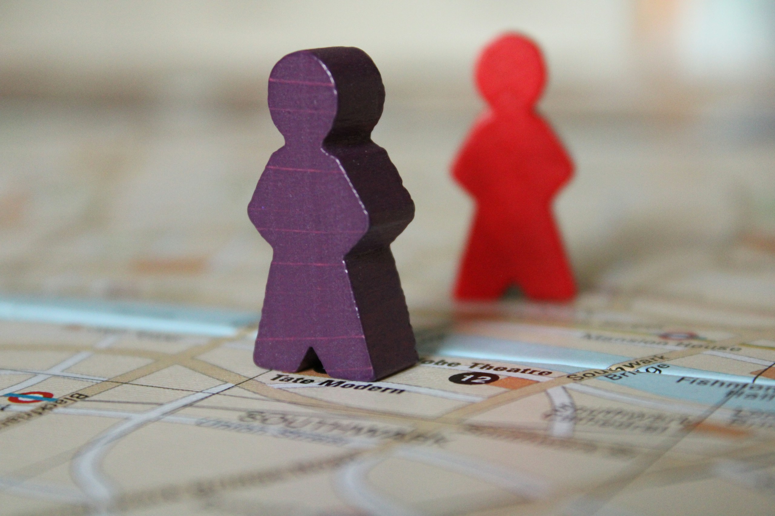 Purple and red wooden meeples on a London map HD Wallpaper