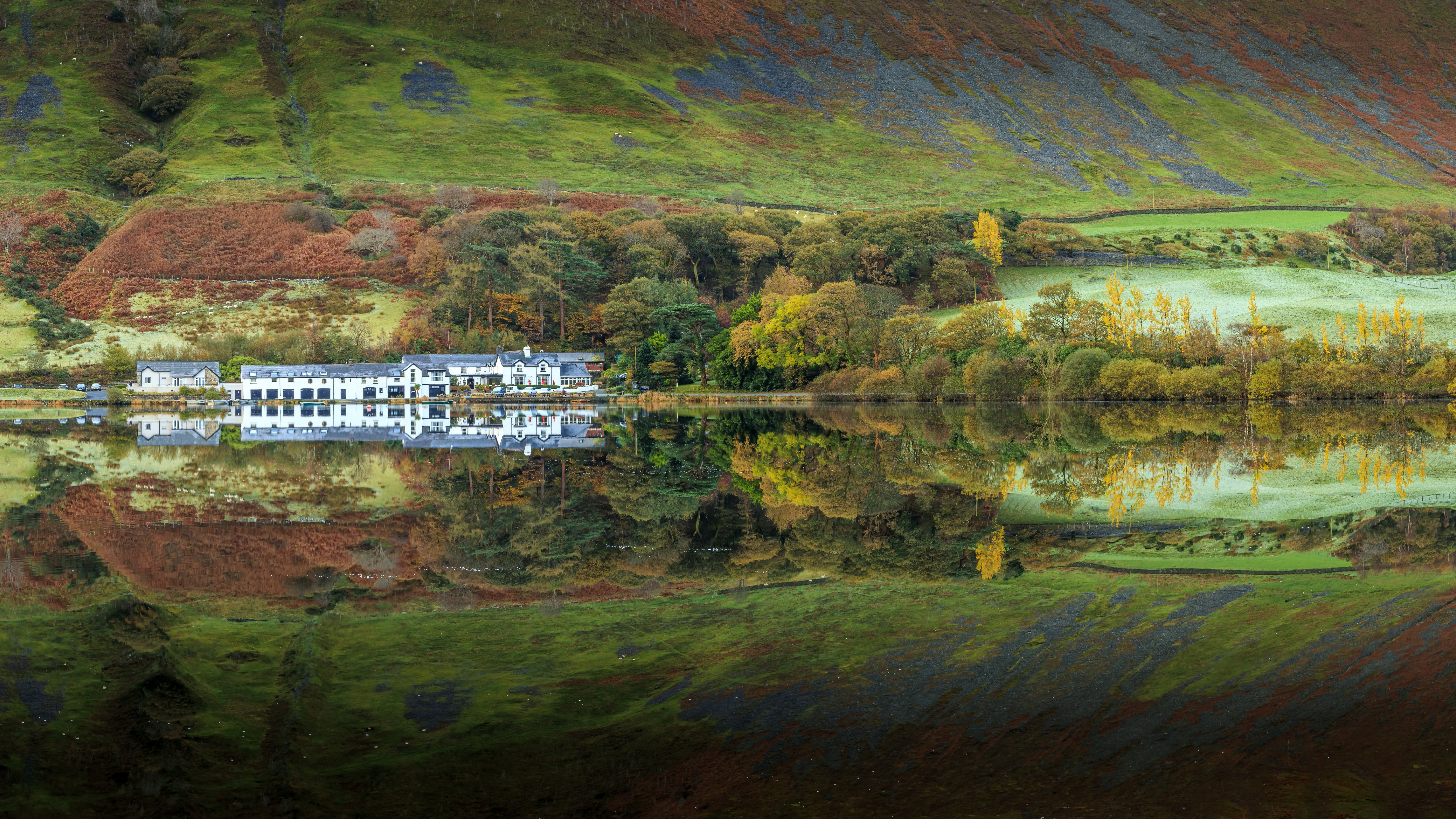White buildings and autumn hills reflected in Buttermere lake HD Wallpaper