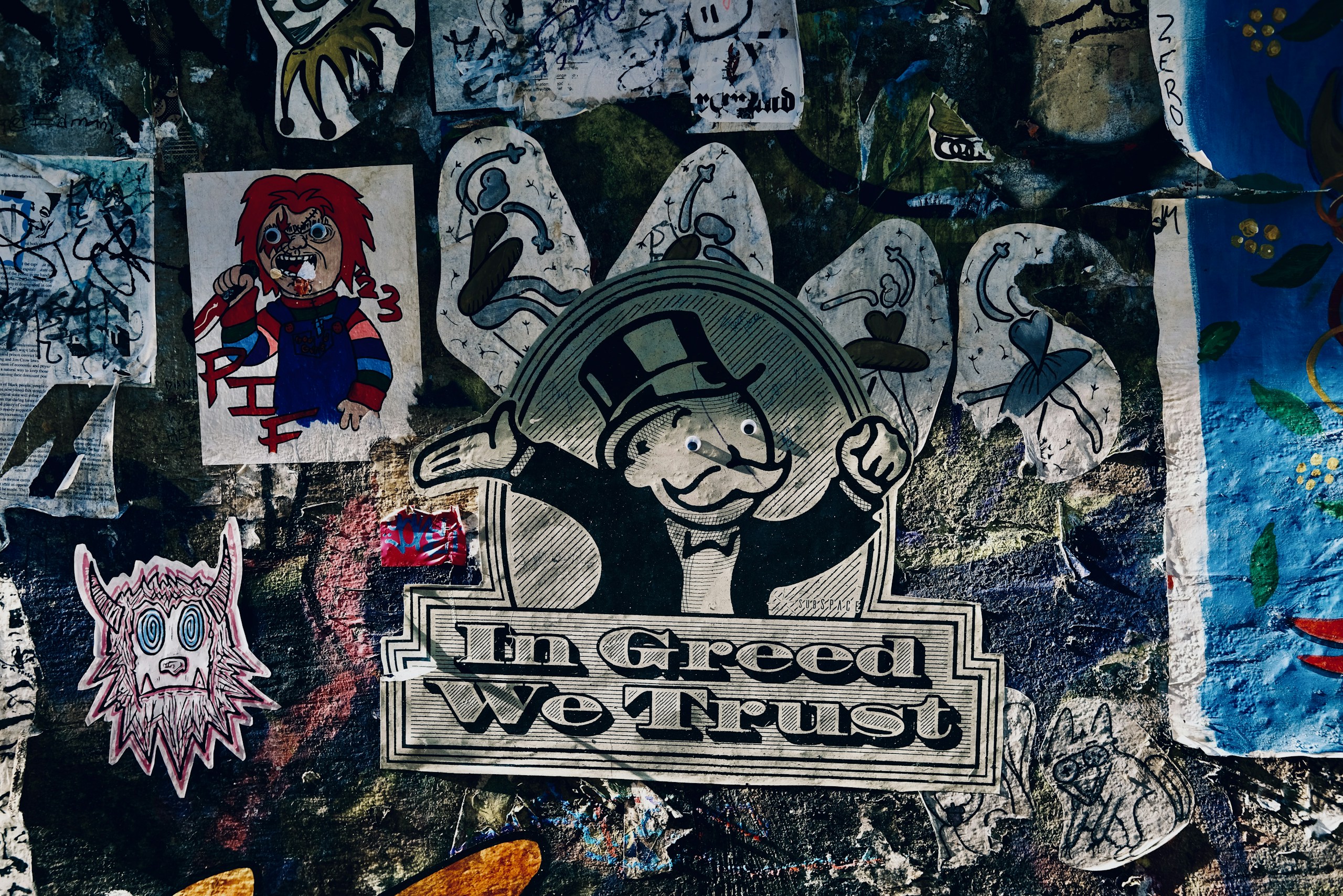 Mr. Monopoly and Chucky stickers on a graffiti wall HD Wallpaper