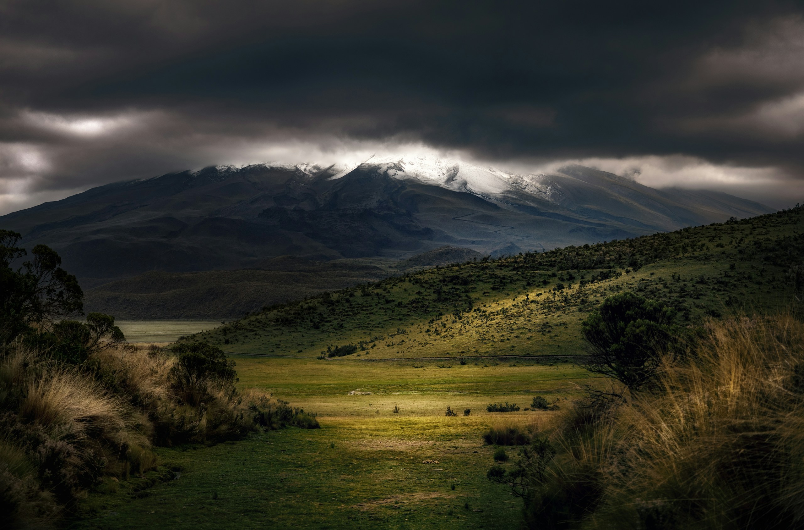 Dramatic storm clouds over a green mountain valley HD Wallpaper