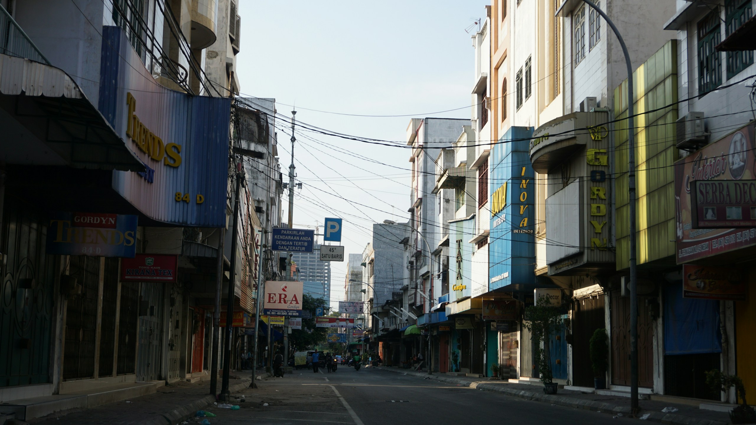 Narrow City Street with Shopfronts and Overhead Wires HD Wallpaper