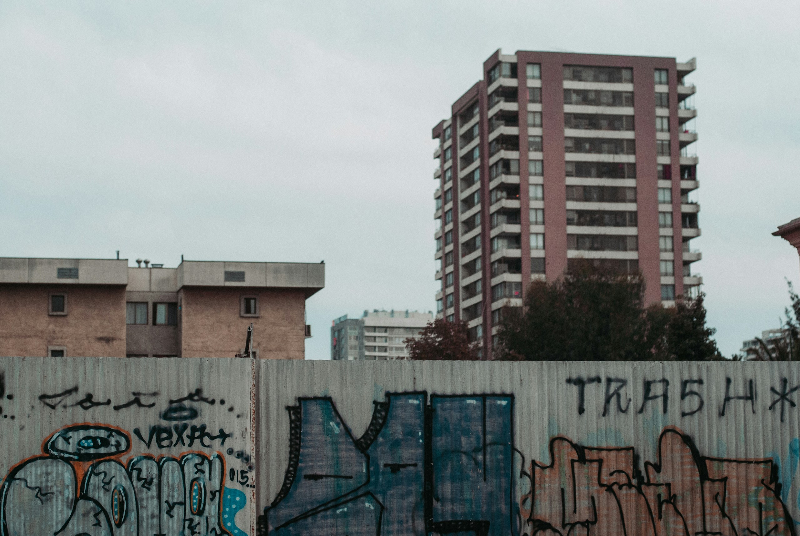 Graffiti covered wall with city buildings in the background HD Wallpaper