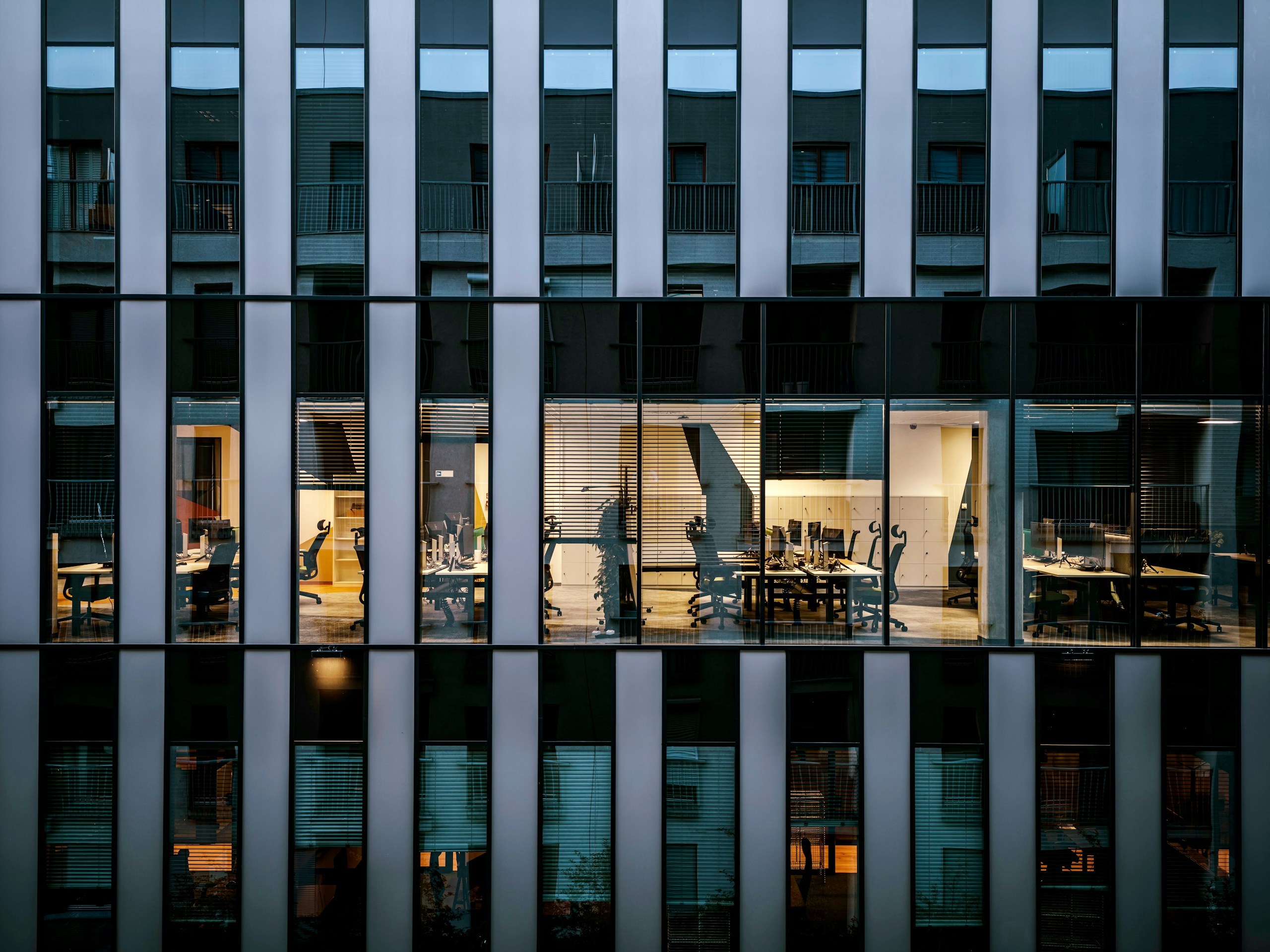Modern Building Facade with Illuminated Office Interior HD Wallpaper