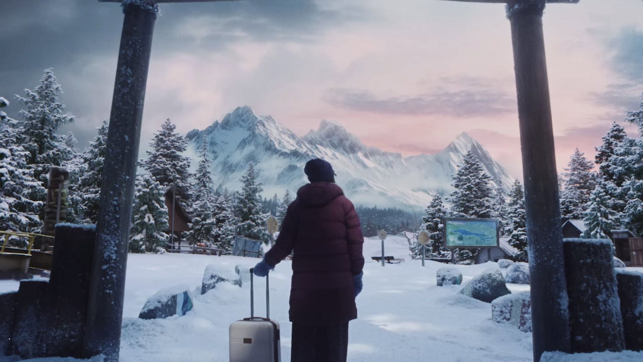 Person with suitcase looking at snowy mountains HD Wallpaper