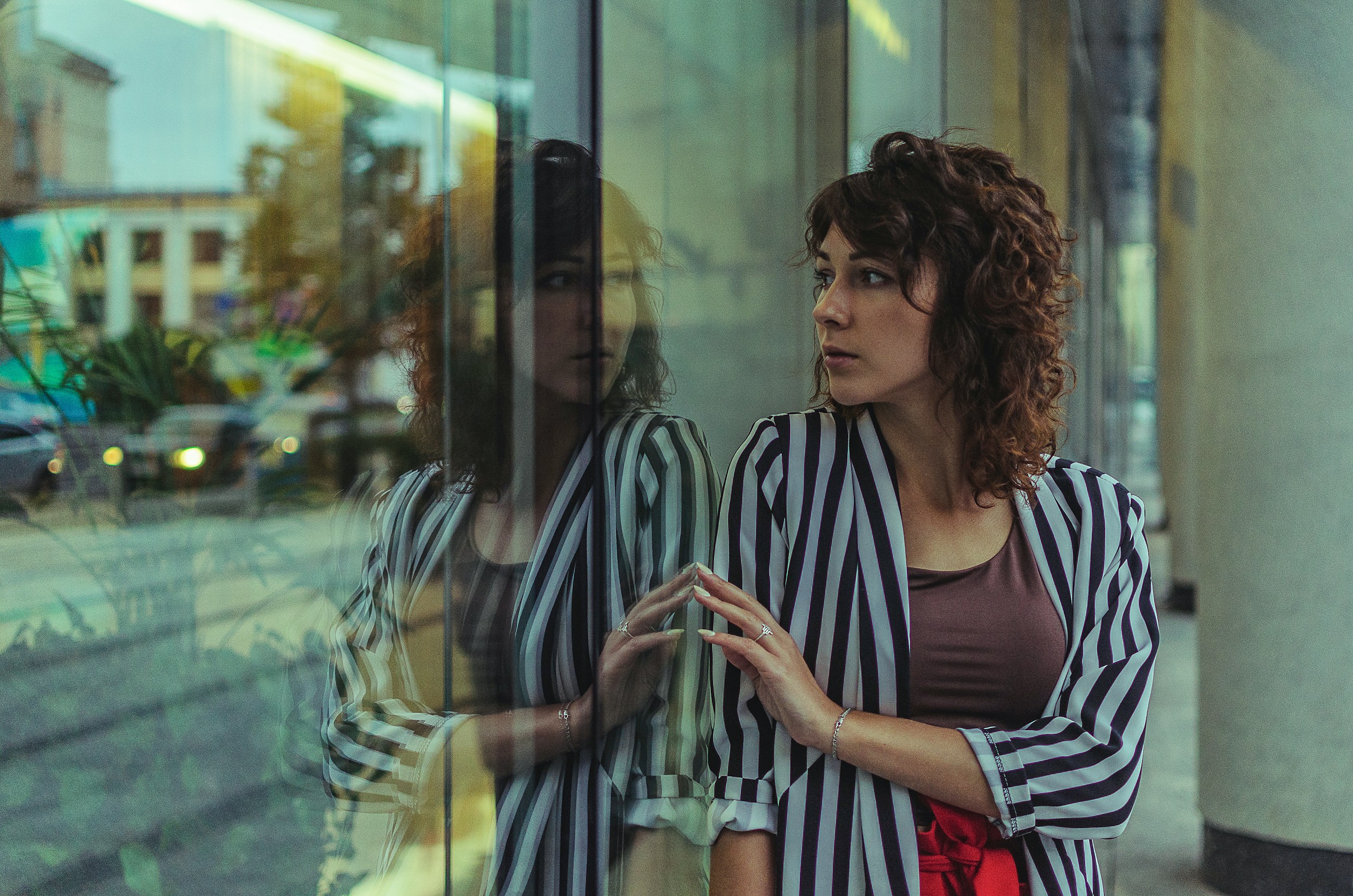 Woman looking at her reflection in a glass window HD Wallpaper