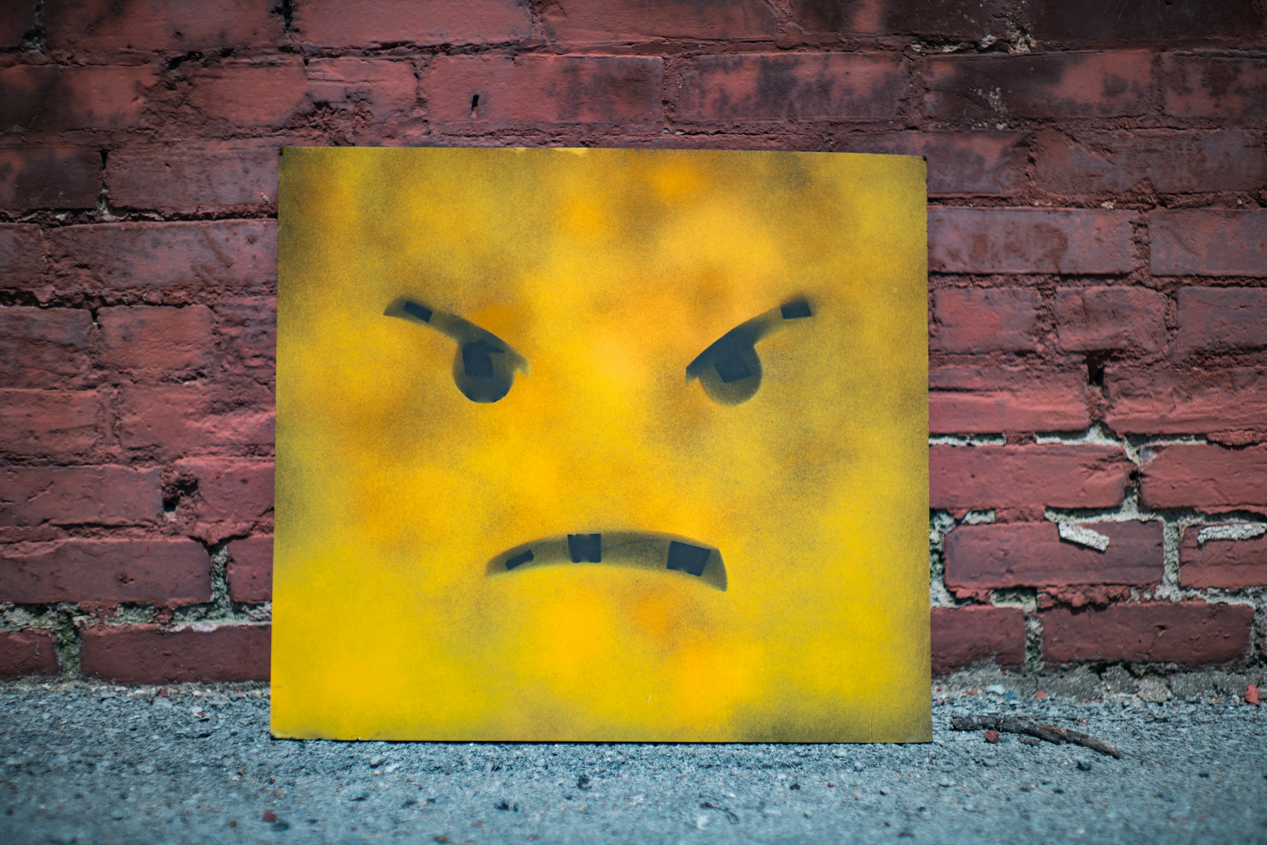 Angry face stencil art on yellow board HD Wallpaper