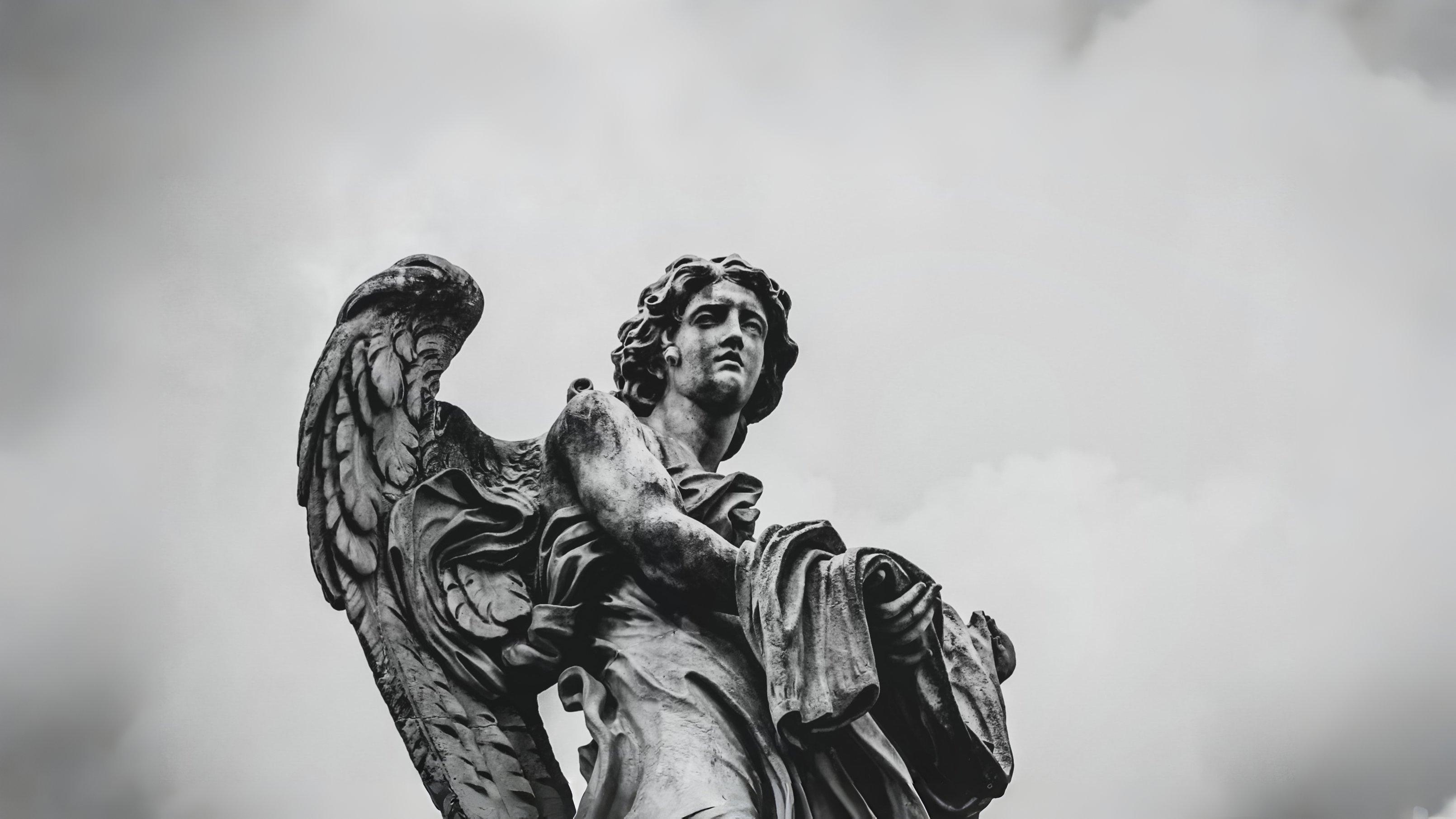Stone angel statue against a cloudy sky HD Wallpaper