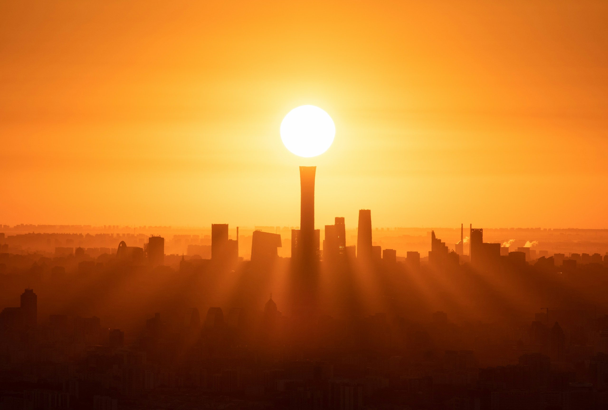 The sun rising directly above a city skyscraper HD Wallpaper