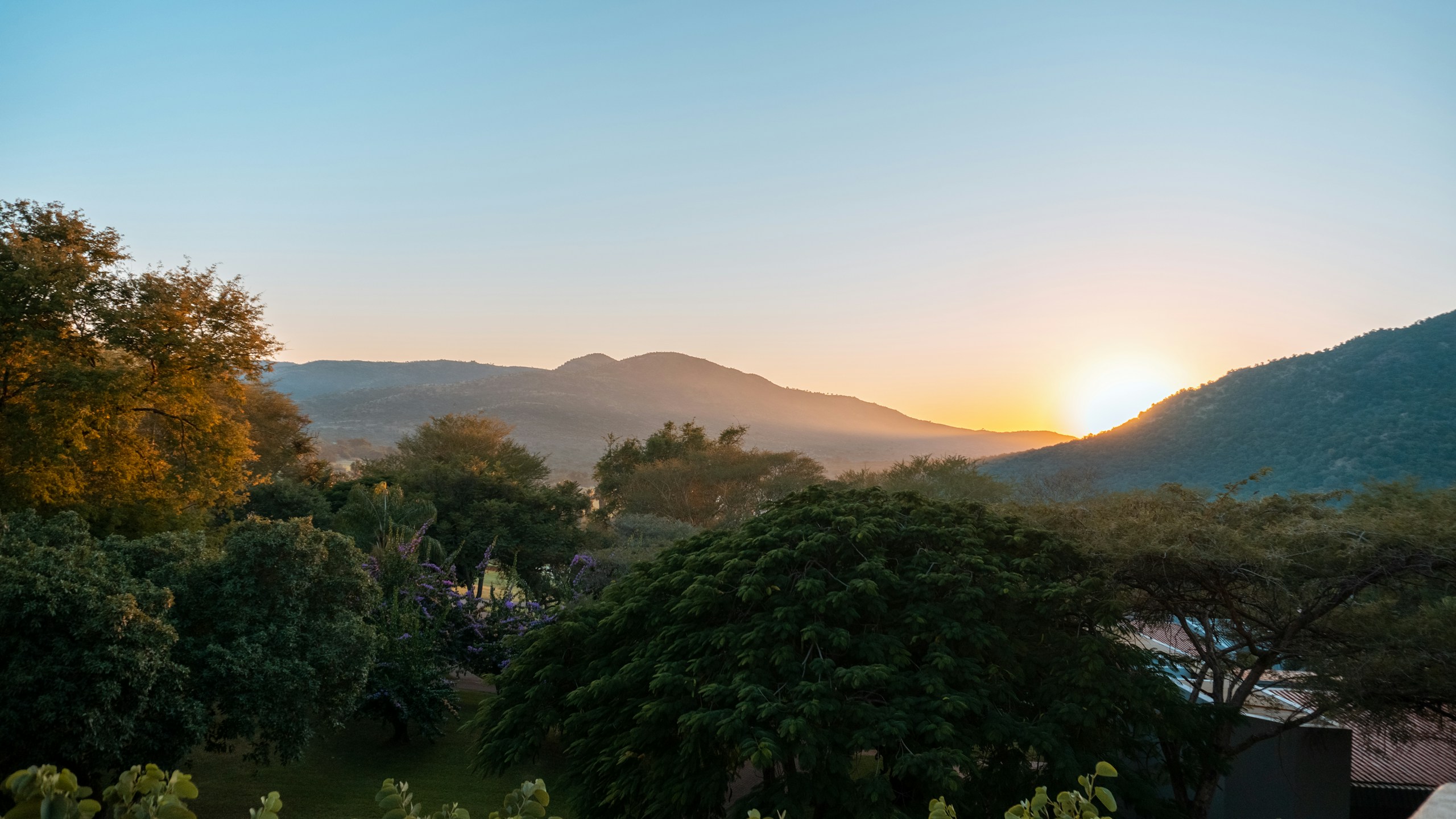 Sunset over mountains and lush green trees HD Wallpaper