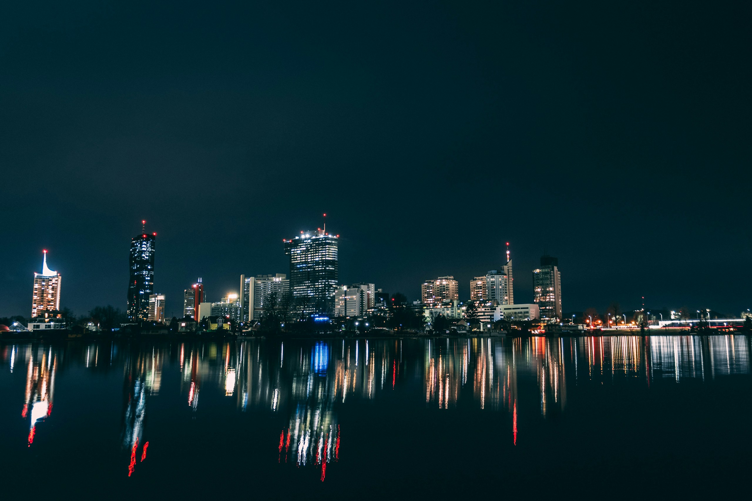 Vienna Donau City skyline reflected in water at night HD Wallpaper