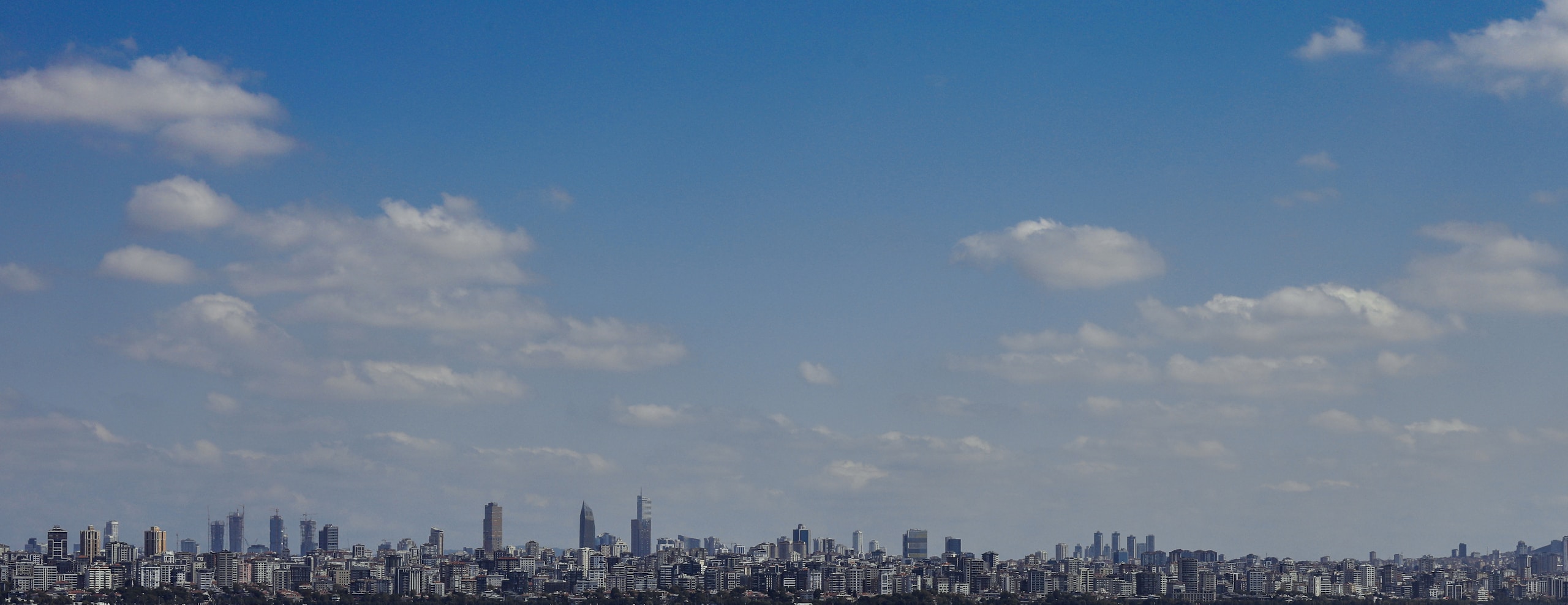 Panoramic view of a city skyline under blue sky HD Wallpaper
