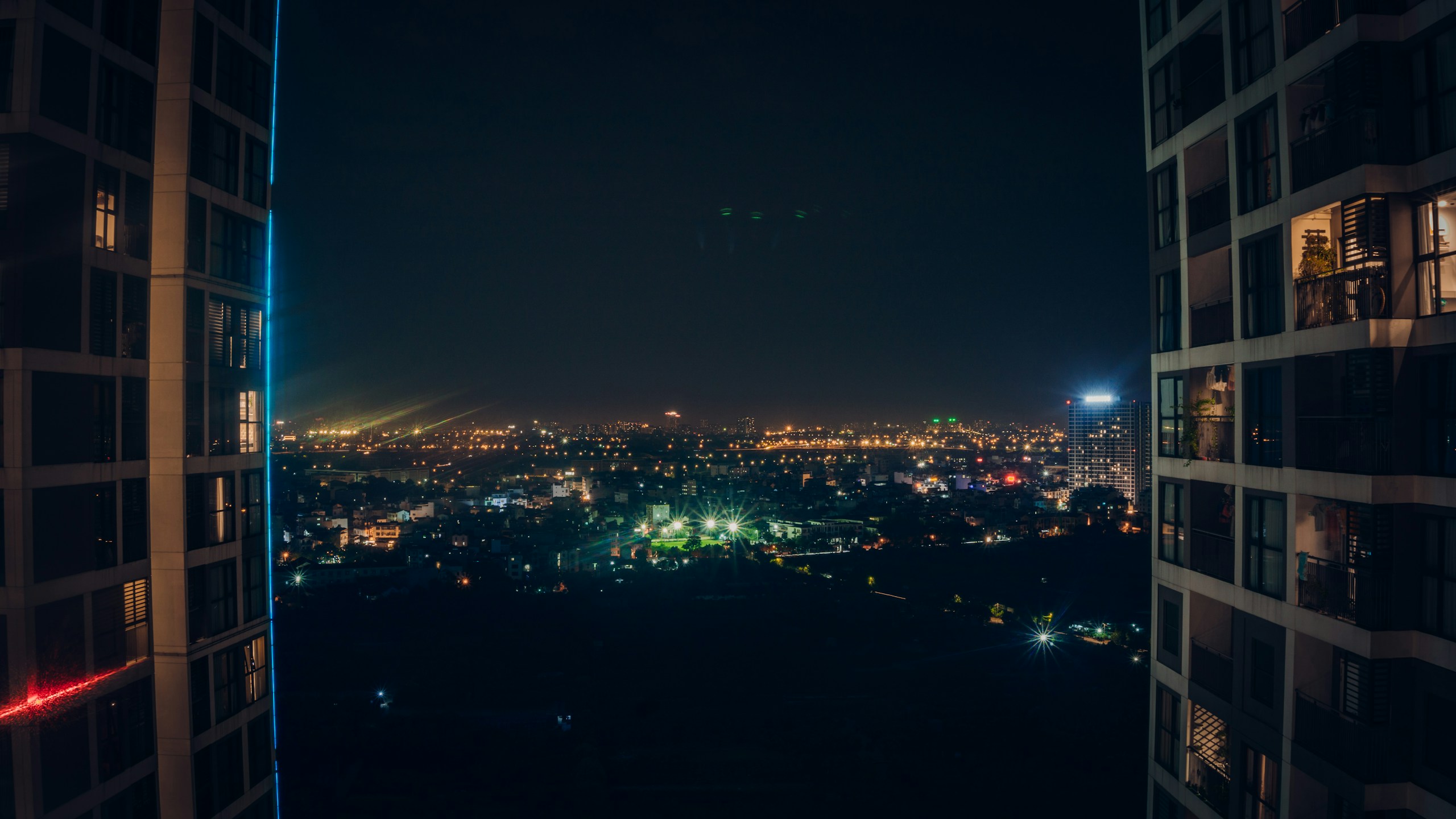 Night view of a city between two tall buildings HD Wallpaper