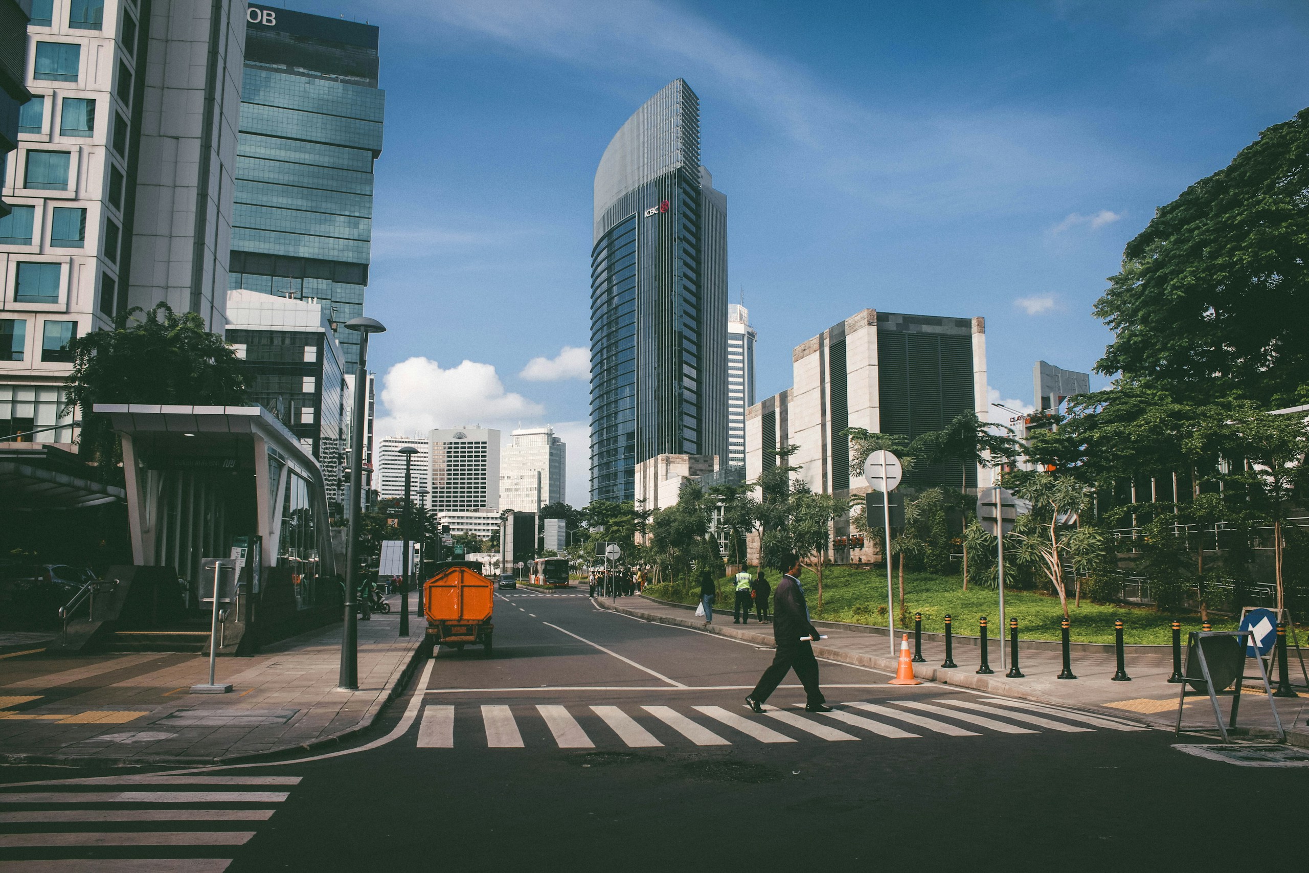 Man crossing a street in Jakarta with Wisma 46 HD Wallpaper