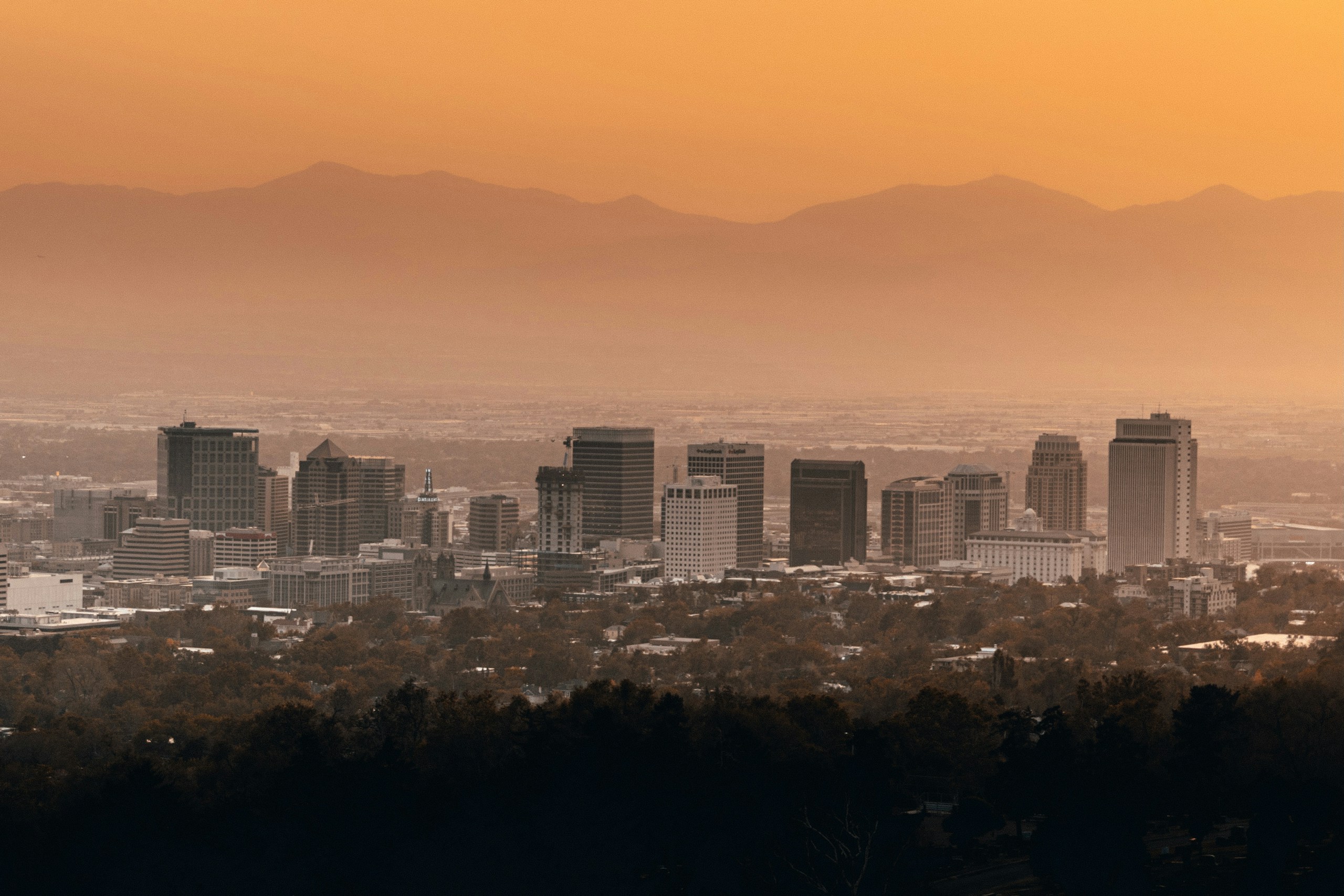Salt Lake City skyline under orange sunset sky HD Wallpaper