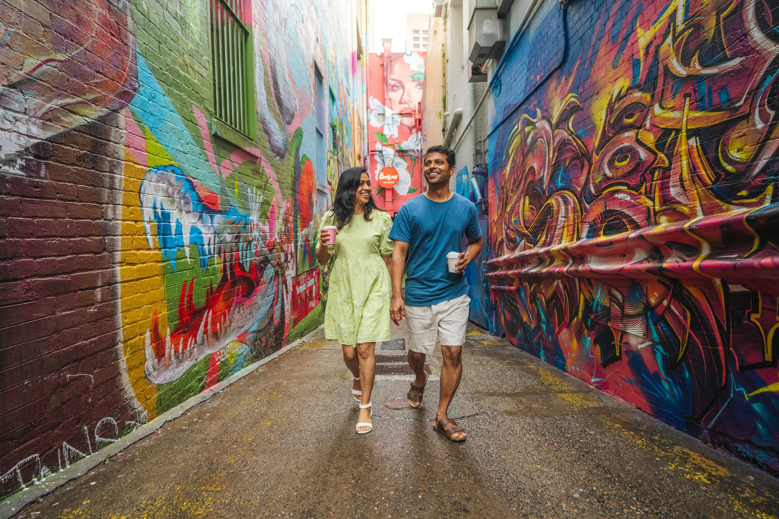 Couple walking through a colorful graffiti alley HD Wallpaper
