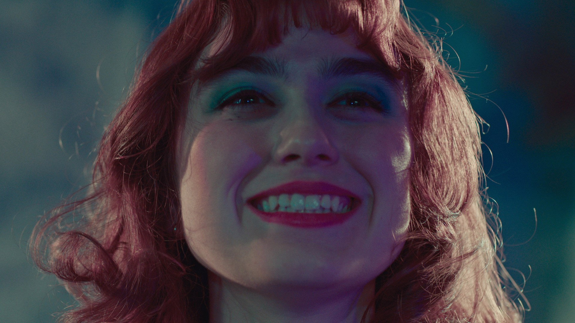 Woman with red hair and blue eyeshadow smiling HD Wallpaper
