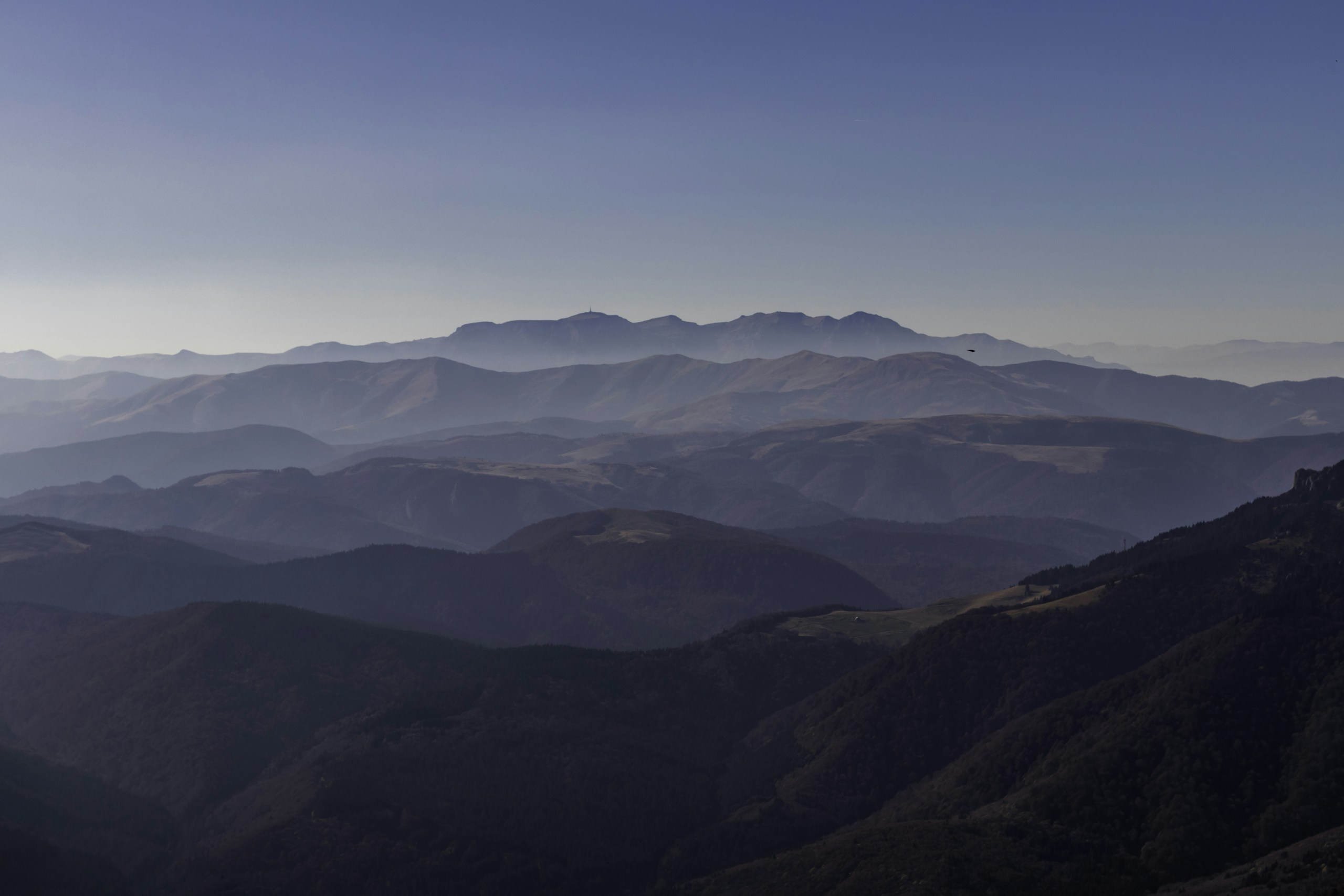 Layered mountain ranges under a clear blue sky HD Wallpaper