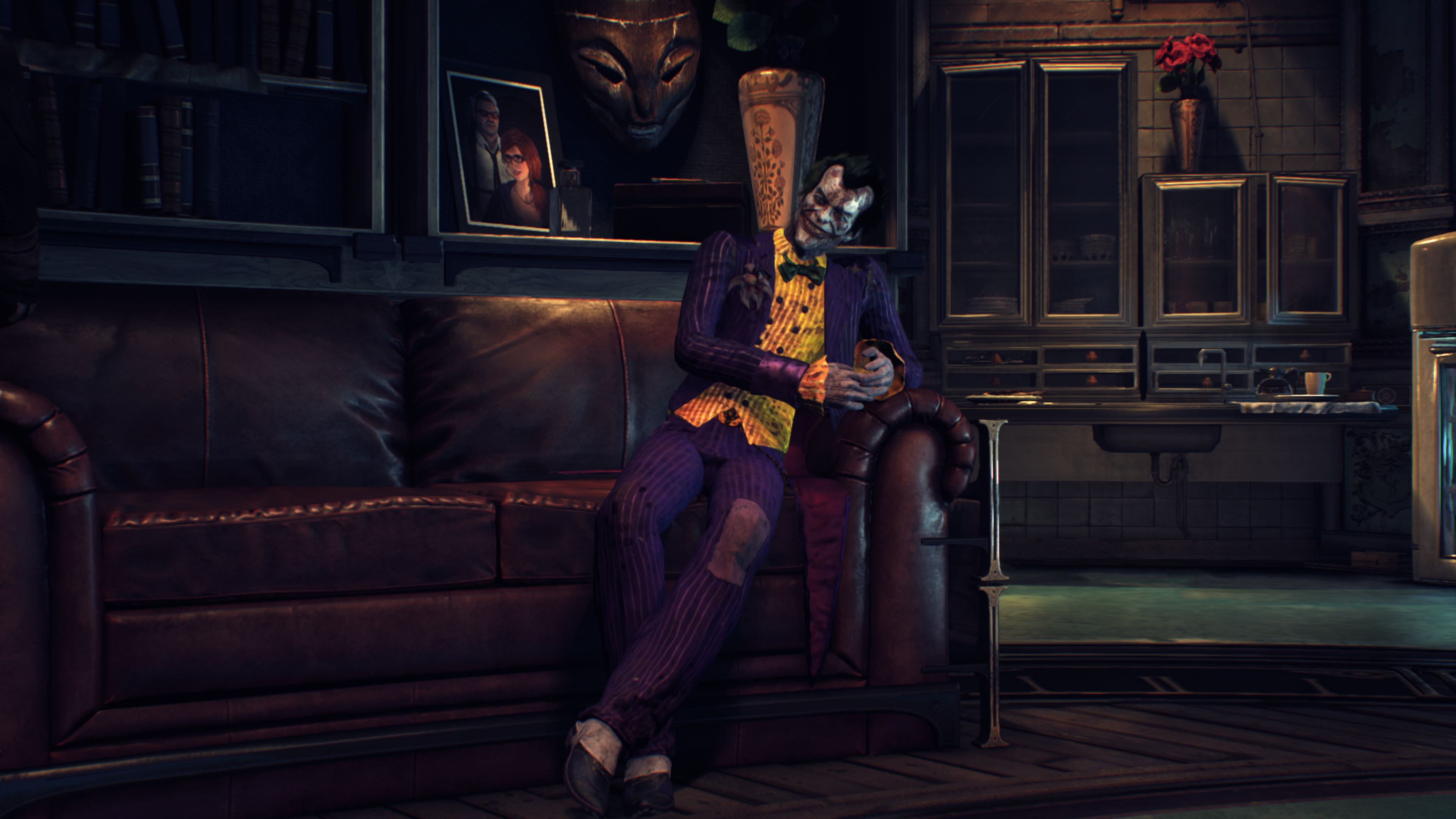 The Joker sitting on a couch in a dimly lit room HD Wallpaper