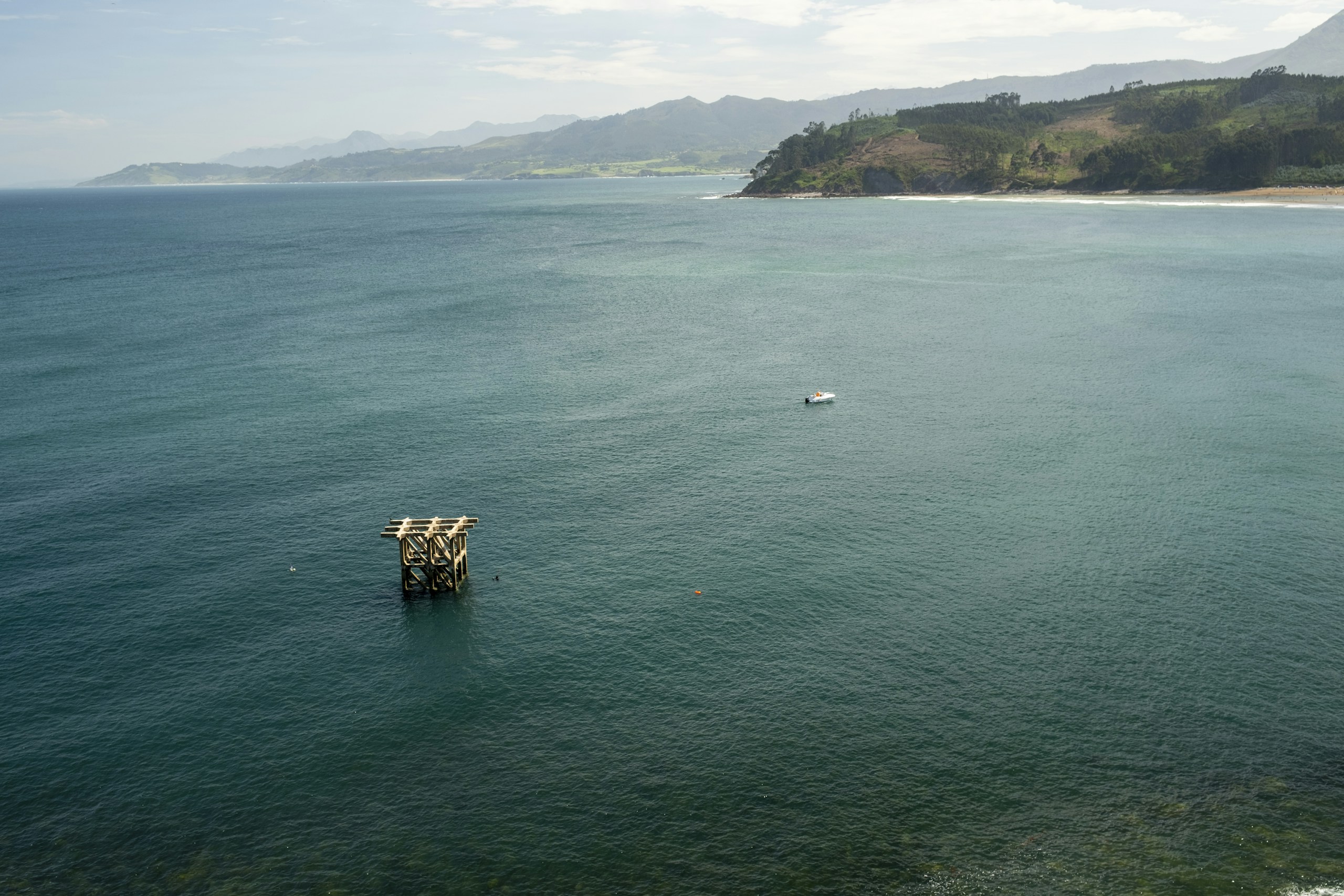 Ocean view with a small boat and pier structure HD Wallpaper