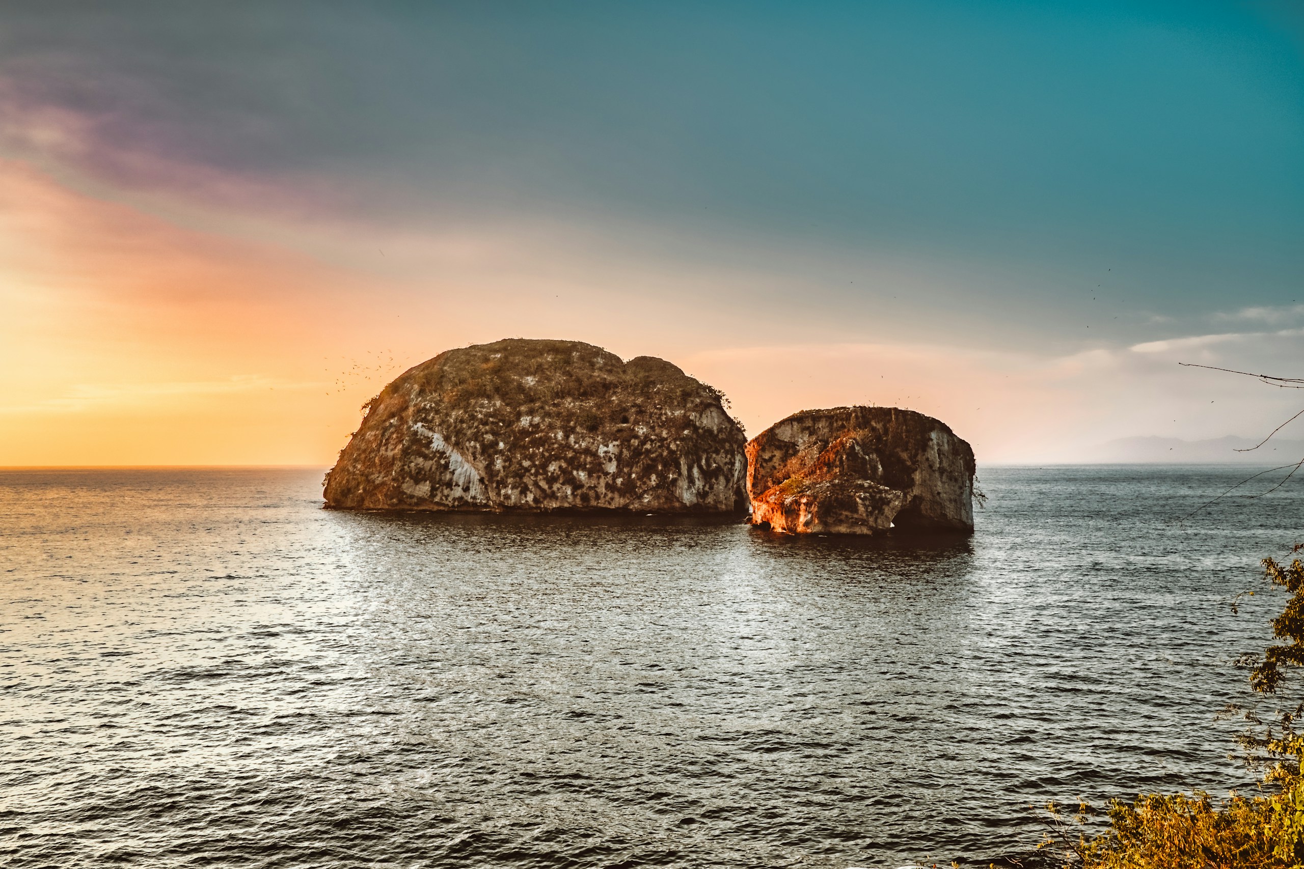 Two rock formations in the ocean at sunset HD Wallpaper