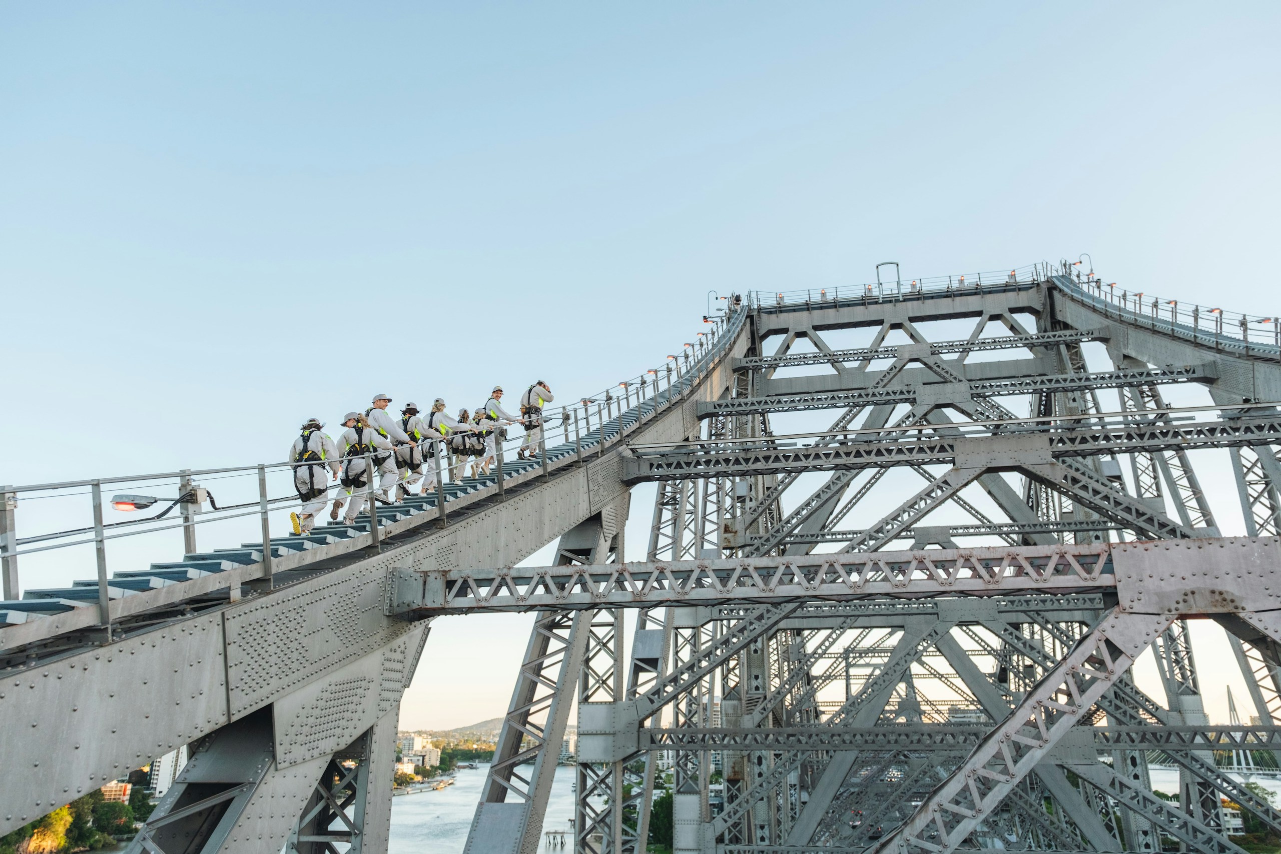 People climbing a large steel bridge structure HD Wallpaper