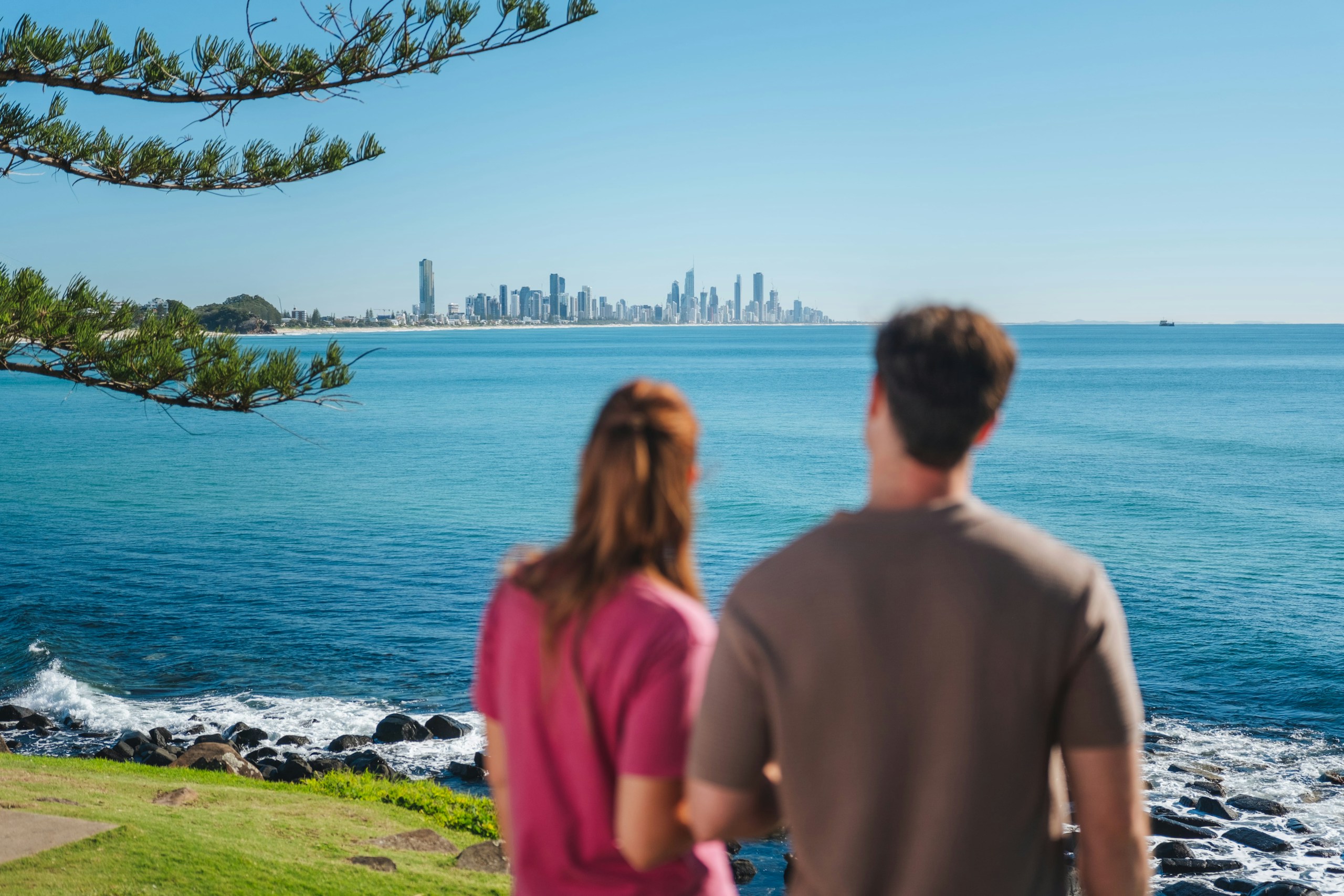 Couple overlooks ocean and city skyline HD Wallpaper