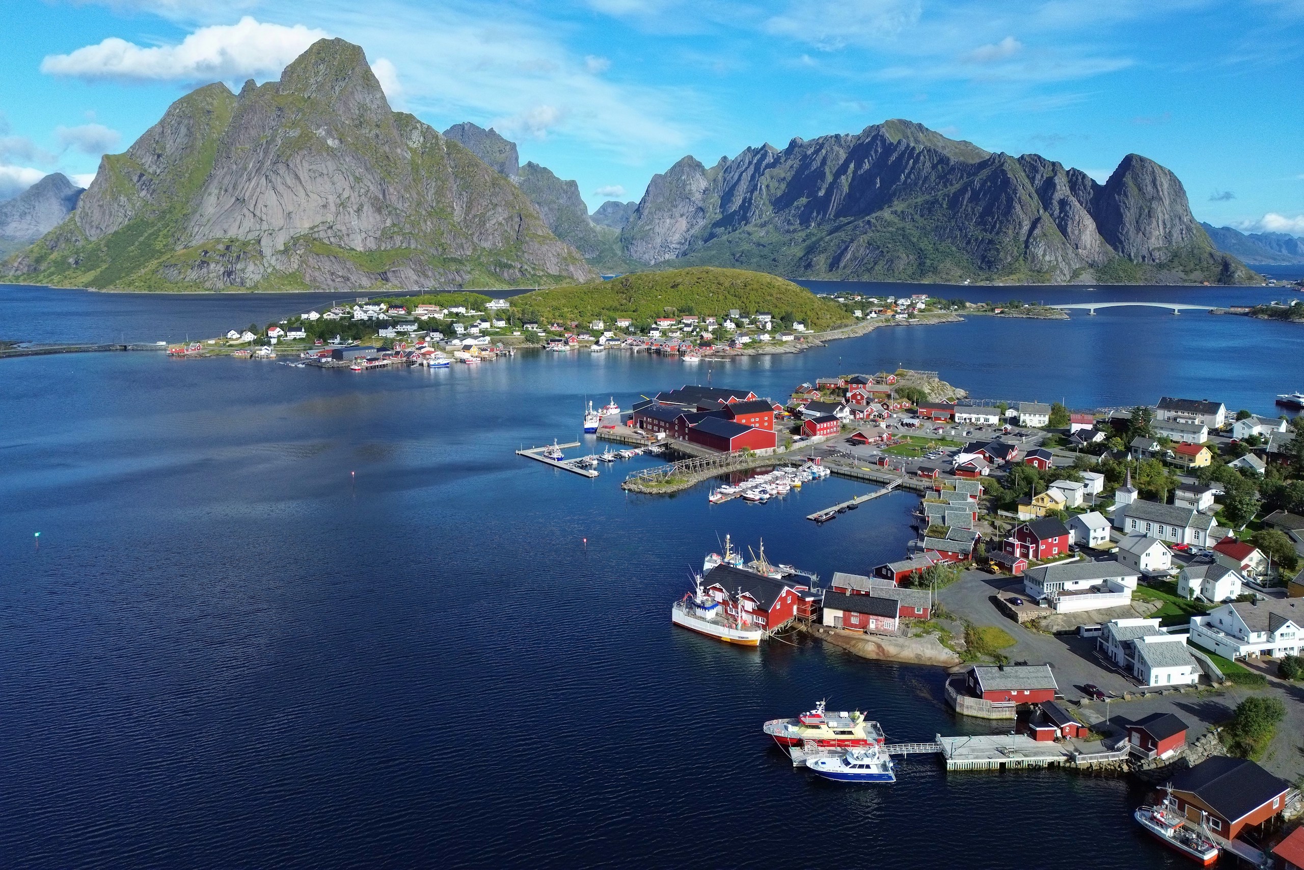 Coastal village nestled among mountains and sea HD Wallpaper