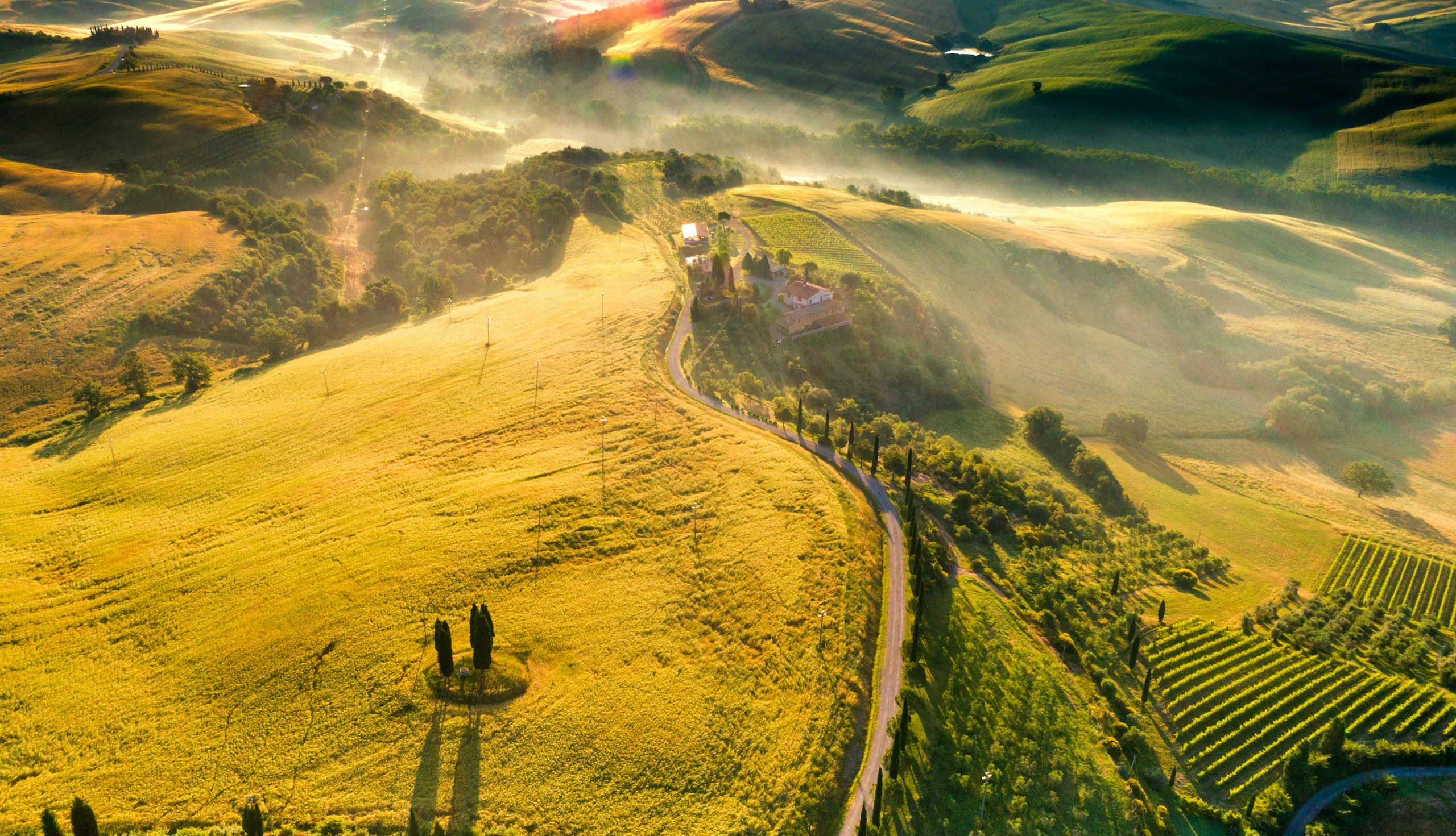 Aerial view of Tuscan landscape with rolling hills and cypress trees HD Wallpaper