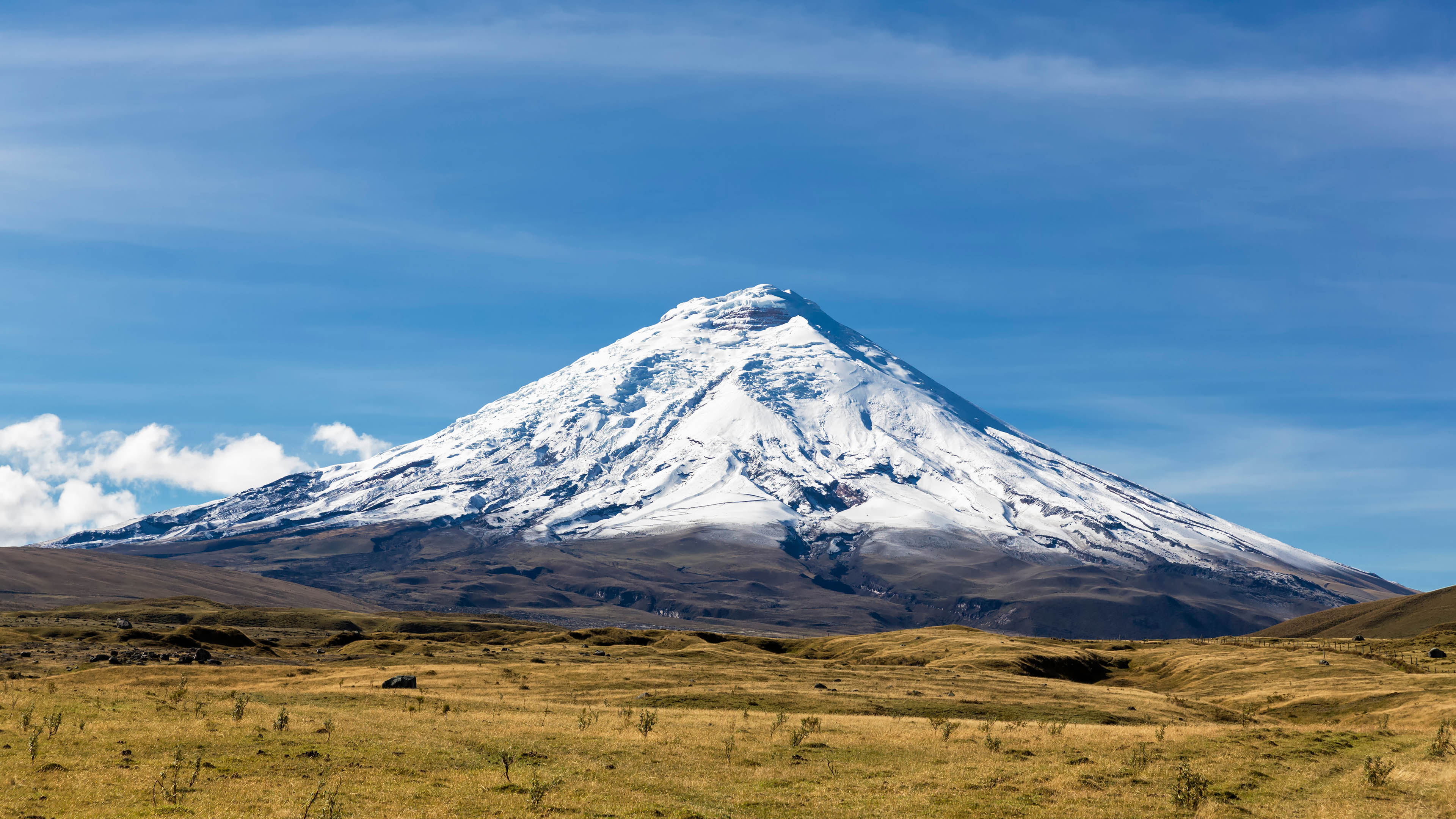 Snow-capped volcano under a blue sky HD Wallpaper