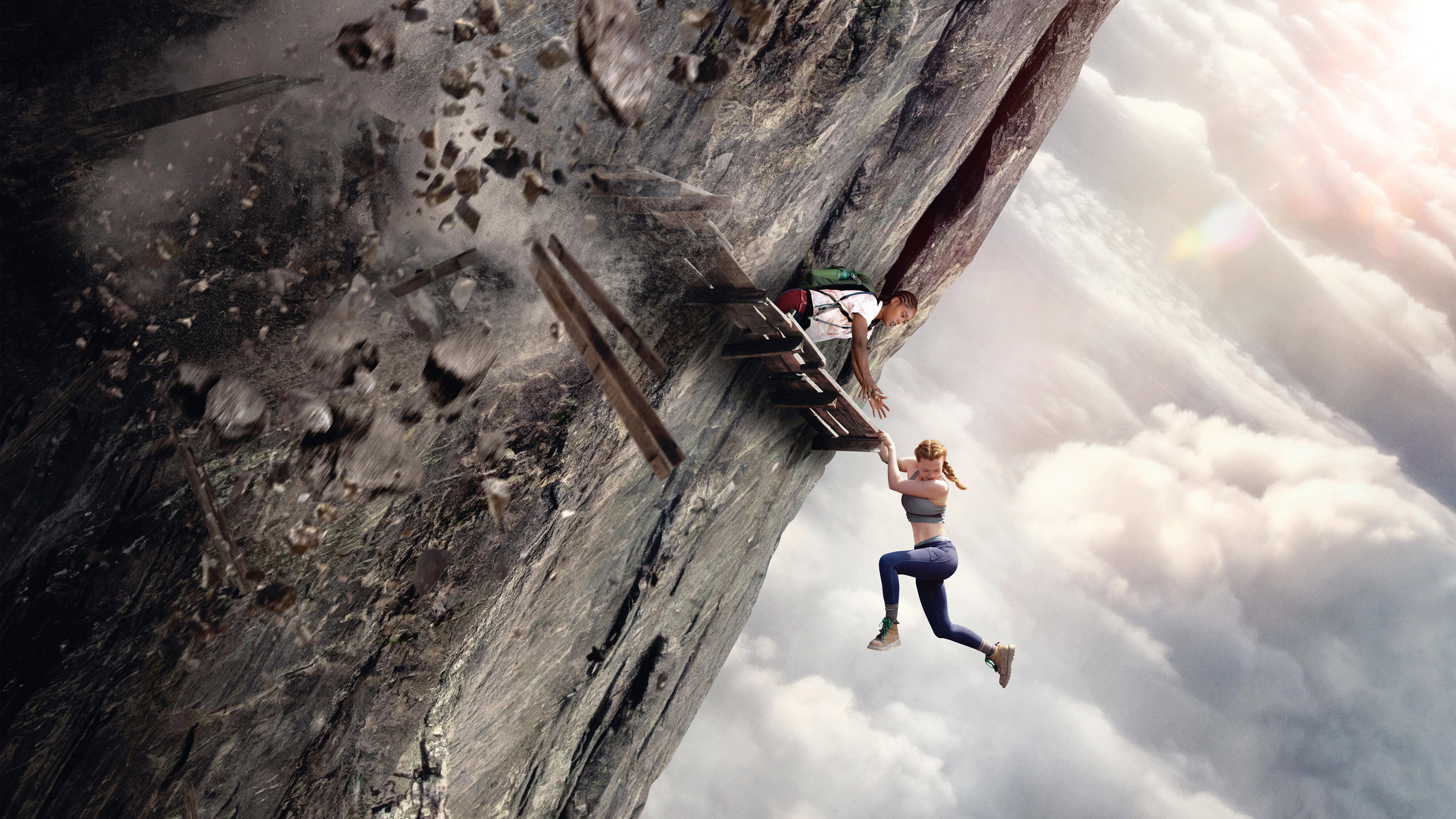 Two women clinging to a collapsing cliffside structure HD Wallpaper