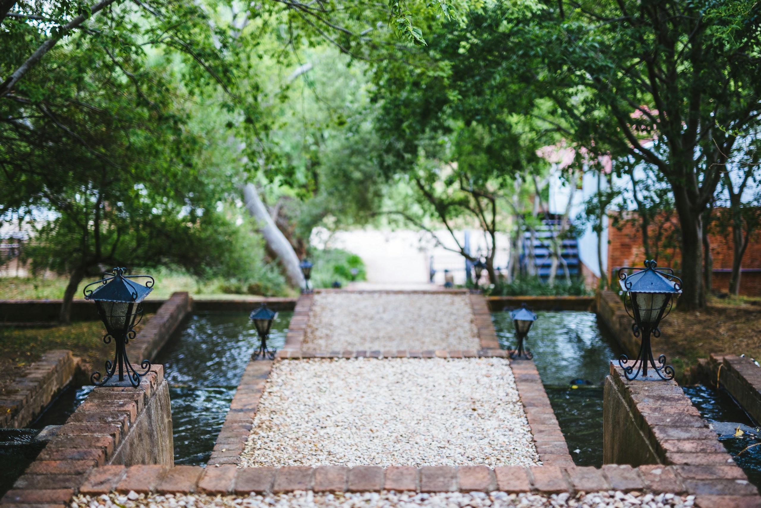 Pathway through a garden with water features and lamps HD Wallpaper