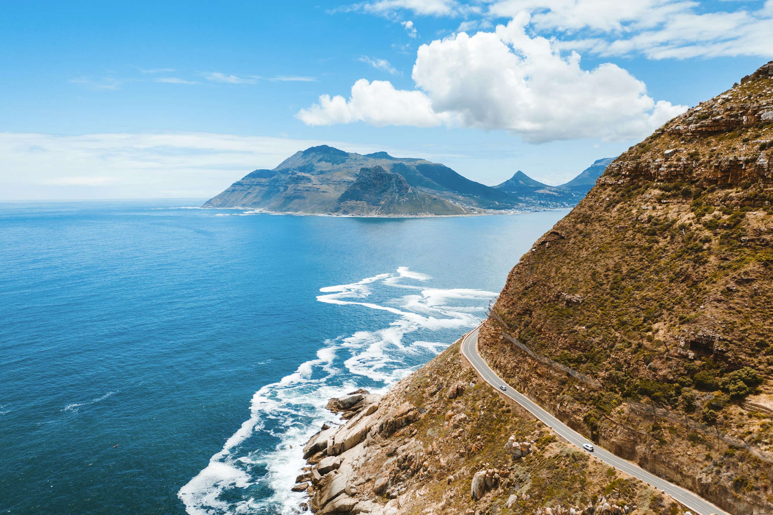 Coastal road winding along a mountain by the ocean HD Wallpaper