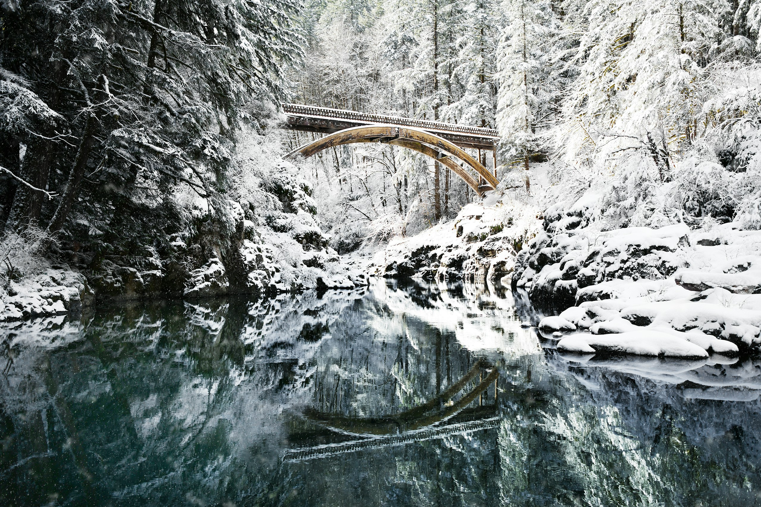 Snowy bridge over a river in a forest HD Wallpaper